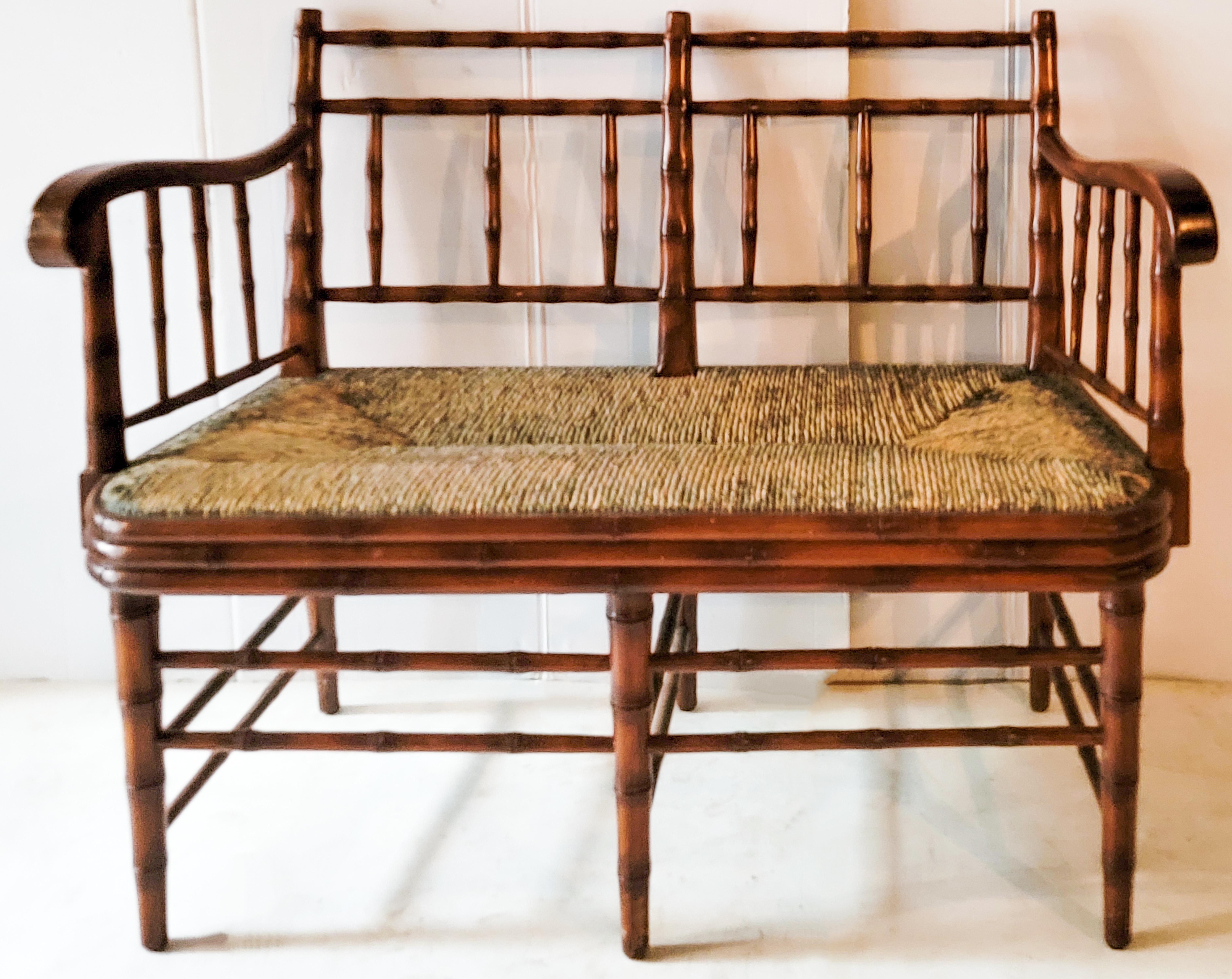 This is a nice little French style faux bamboo bench or settee with a rush seat by Sarreid out of Spain. It is marked and in very good condition. Measure: Arm;30.5”.