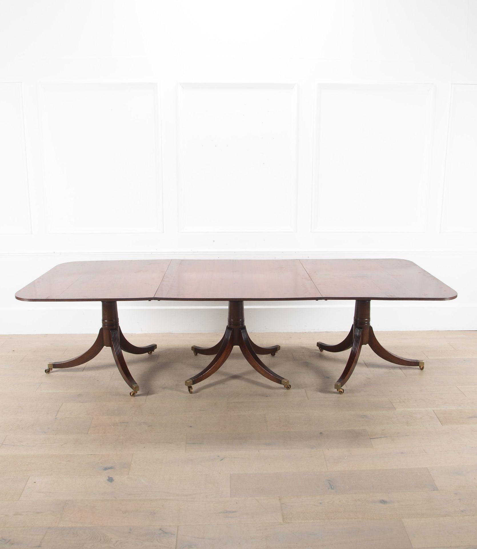Table de salle à manger à rallonge en acajou de la fin du 20e siècle, de style George III, avec bord cannelé sur le dessus.
Soutenu par trois piliers tripodes cannelés.
Circa 1970.