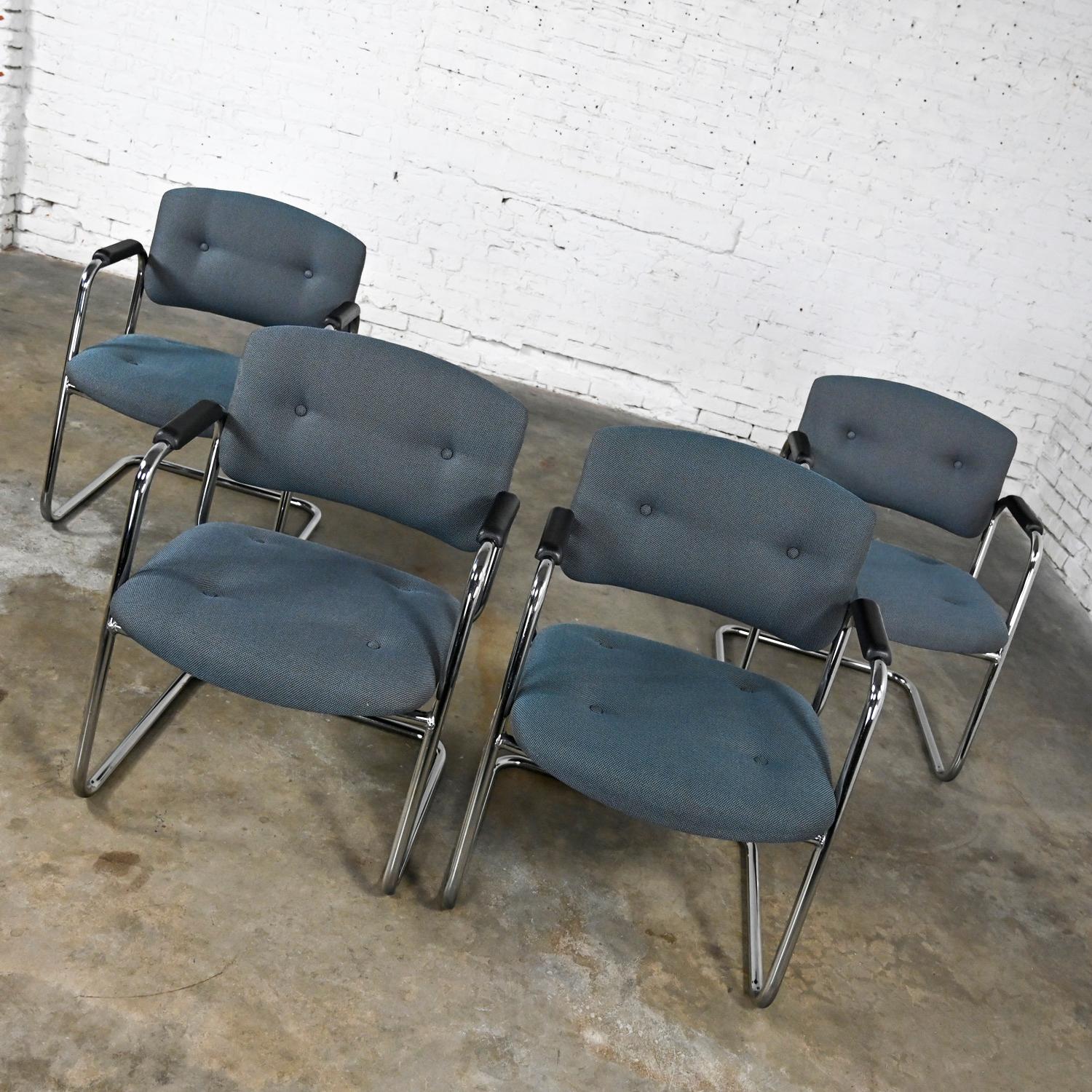 Awesome gray & chrome vintage cantilever chairs by United Chair Company in the style of Steelcase, set of 4. Comprised of a chrome cantilever frame, black plastic armrests, and their original gray tweed fabric with button details. This listing is