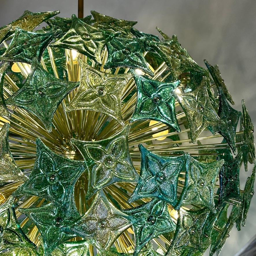 Stunning horizontal oval shape brass sputnik chandelier with three tones of green Louis Vuitton logos made of Murano art glass with gold dust inside.
Each Murano art glass plate is kept into place with a brass screw.
16 E14 Light Bulbs (recommended