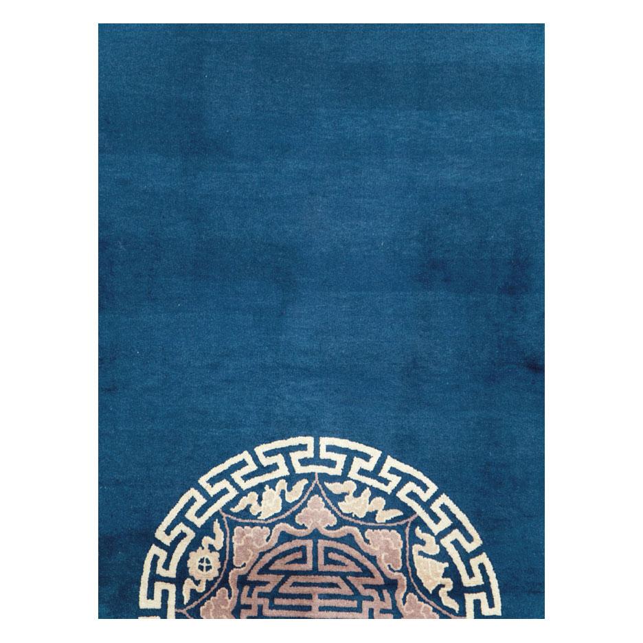A vintage Chinese Peking room size carpet handmade during the late 20th century in blue, mauve, and cream.

Measures: 9' 1