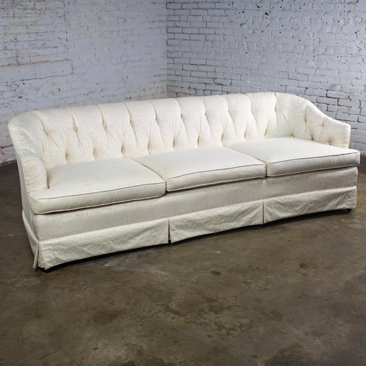 Wonderful vintage Hollywood Regency sofa by Waters wearing an off-white Brocade fabric with textured leaf details, button tufted back, curved arms w/separate arm covers, 2 poly filled throw pillows, three loose & zippered poly wrapped foam seat