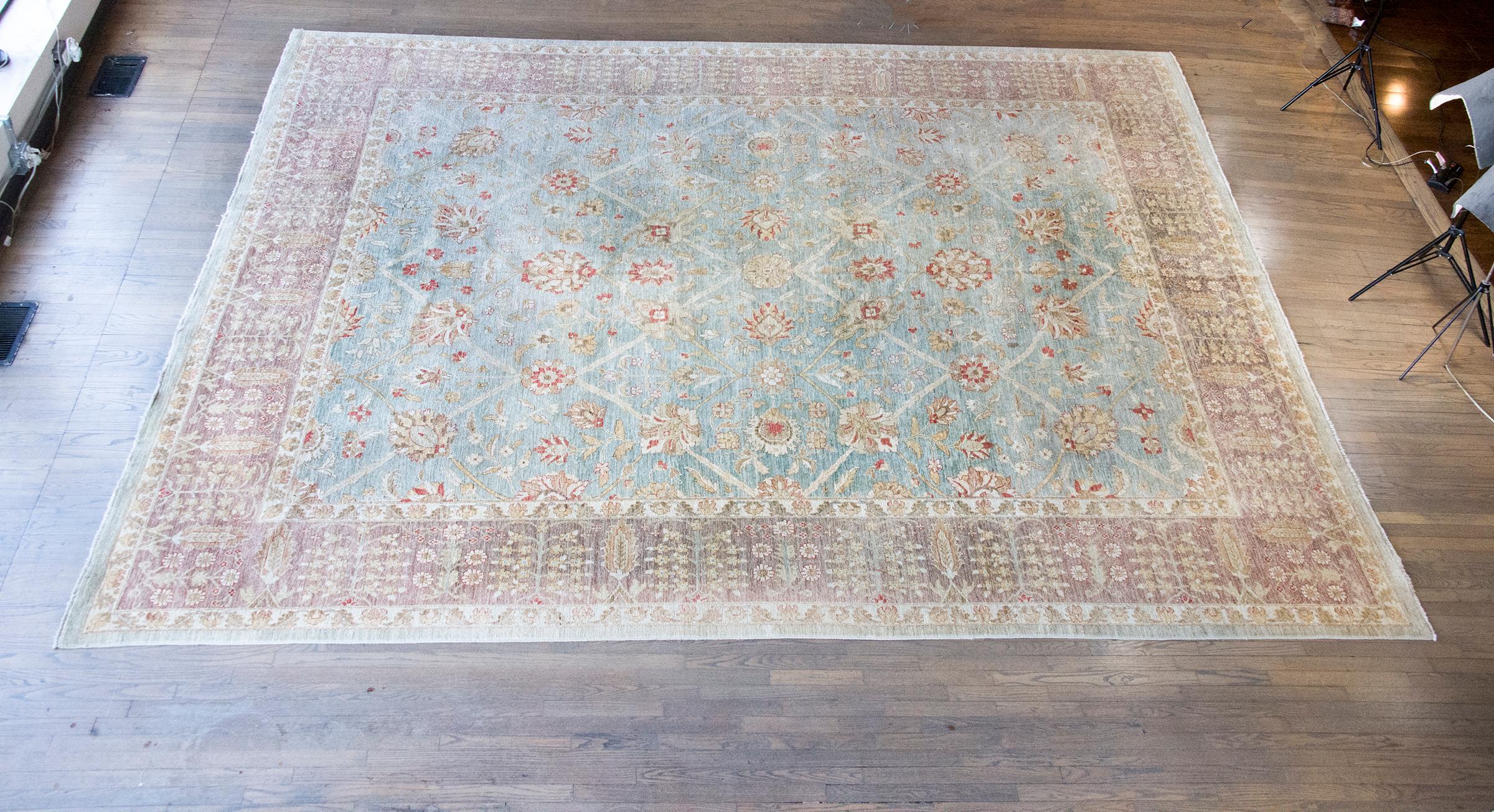 This vintage late 20th-century Indian hand-knotted rug beautifully interprets the classic Persian Sultanabad pattern, renowned for its elegance and grandeur. Crafted with exceptional attention to detail, the rug’s field is adorned with a graceful
