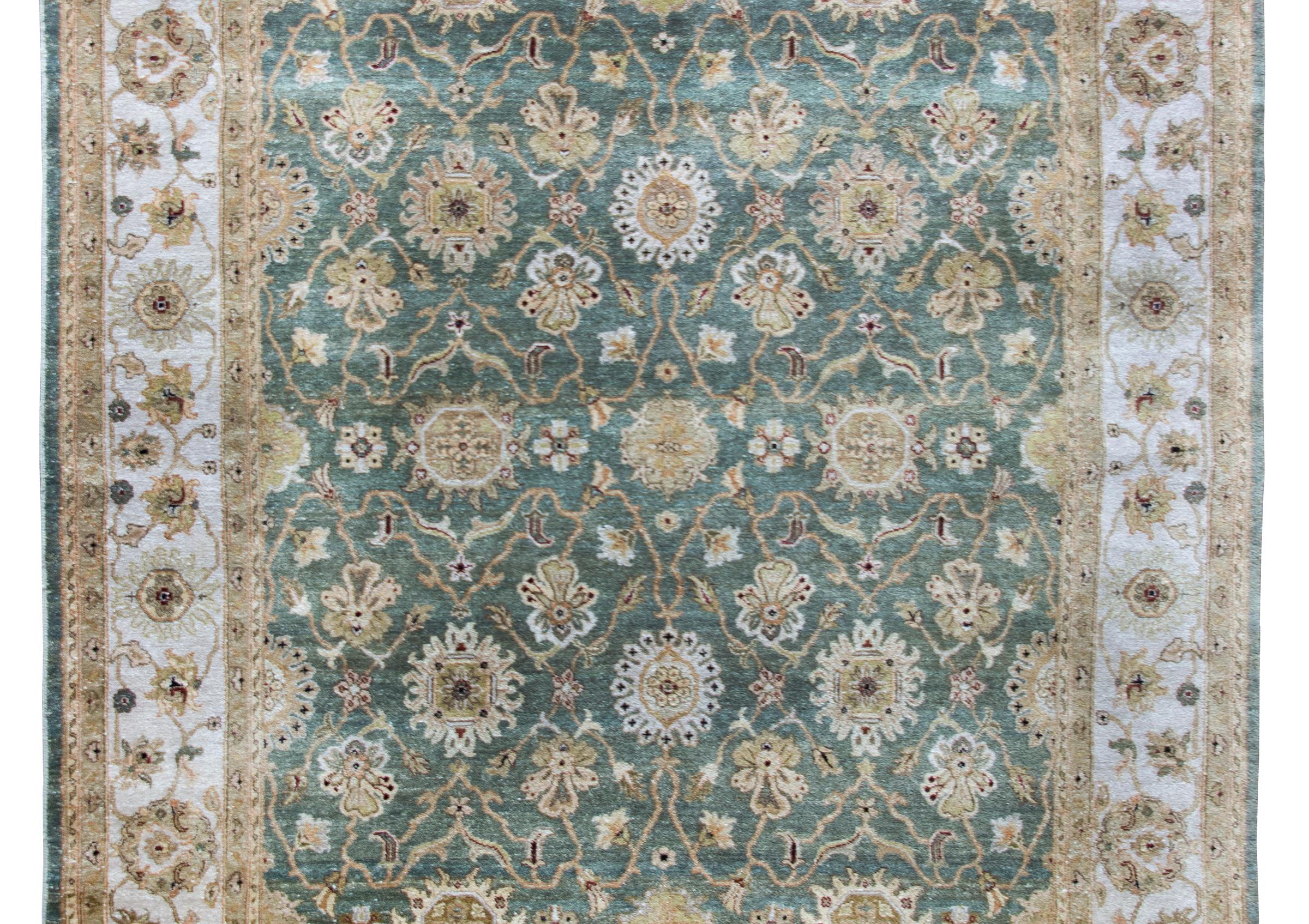 Superbe tapis indien de style Tabriz de la fin du 20e siècle. Il présente un motif floral en treillis avec de grandes fleurs et des vignes enroulées, tissé dans des tons de beige, de blanc, de vert sauge et de cramoisi, le tout entouré d'une large