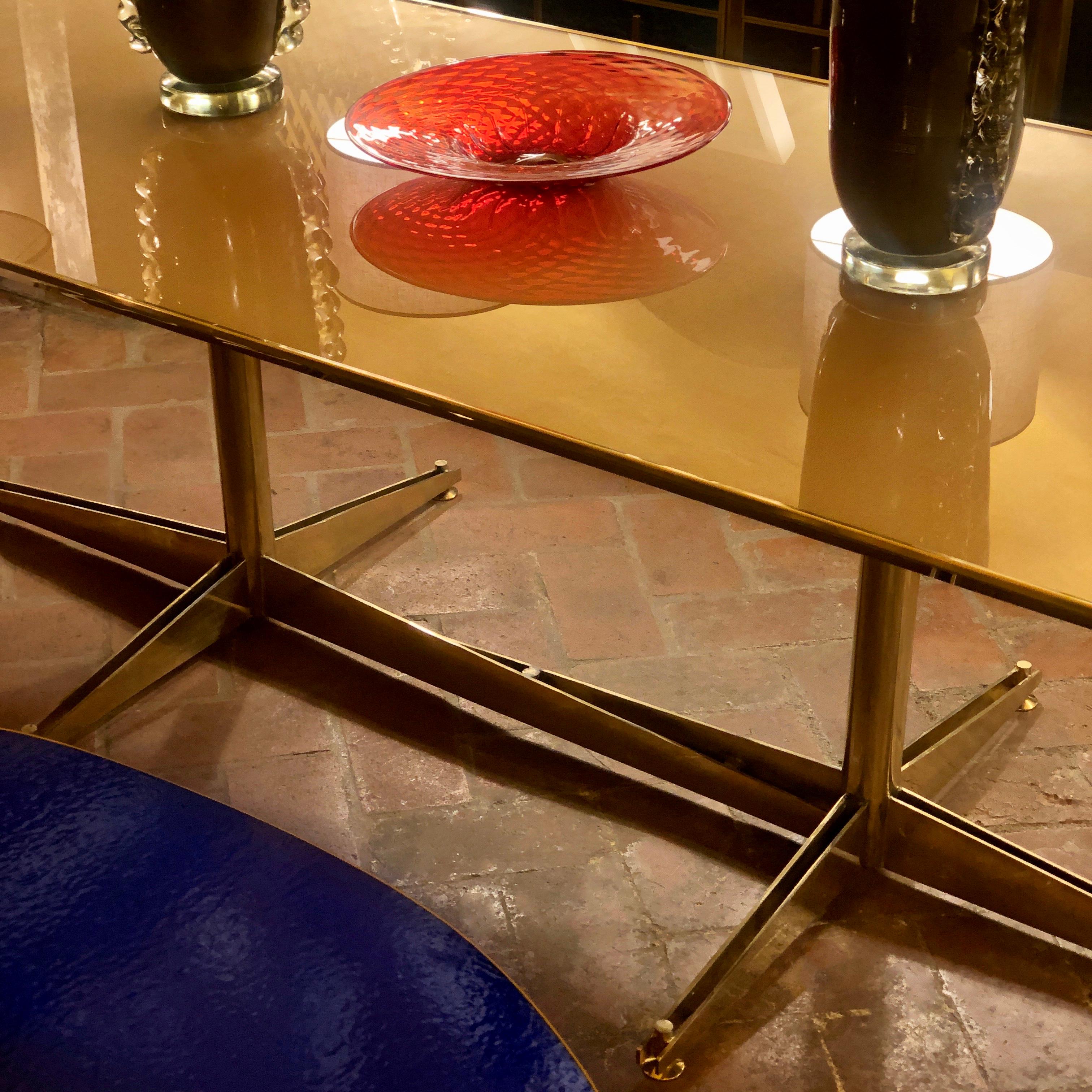 Gold wire mesh underneath the glass top.
Adjustable brass feet.
The top of the table can be taken apart for easier delivery.