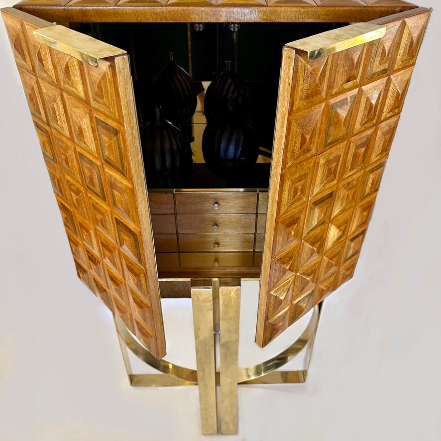 This amazing cabinet made of one hundred and eigty handmade carved cypress tiles painted with shellac, standing on a Vitruvian style brass basement (an oval brass band inside three rectangulars) is a must have for any entrance statement, living room