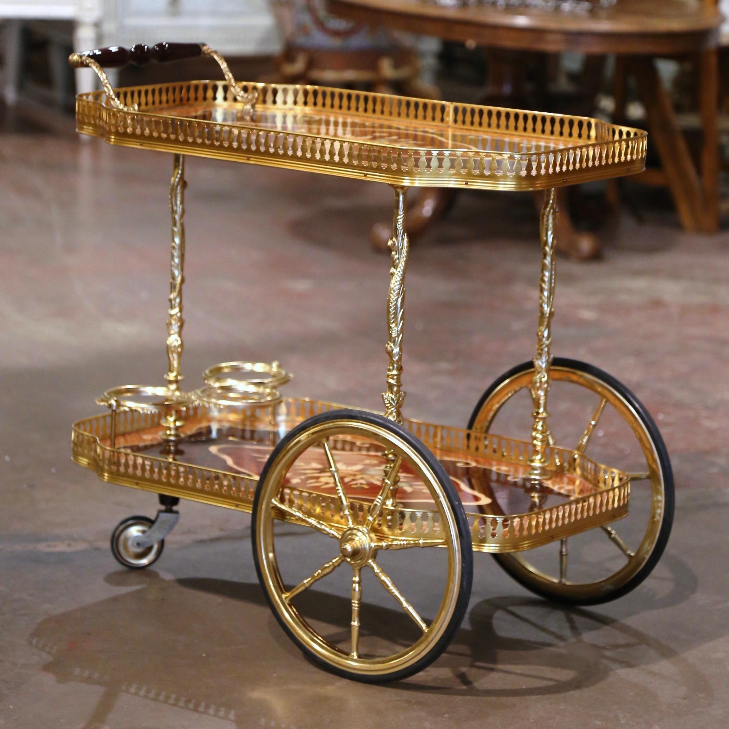 This elegant two-tier marquetry and gilt brass cart was created in Italy, circa 1980. Rectangular in shape with recessed corners, the bar cart sits on side spoked wheels over bamboo shaped legs embellished with foliage motifs. The trolley features a