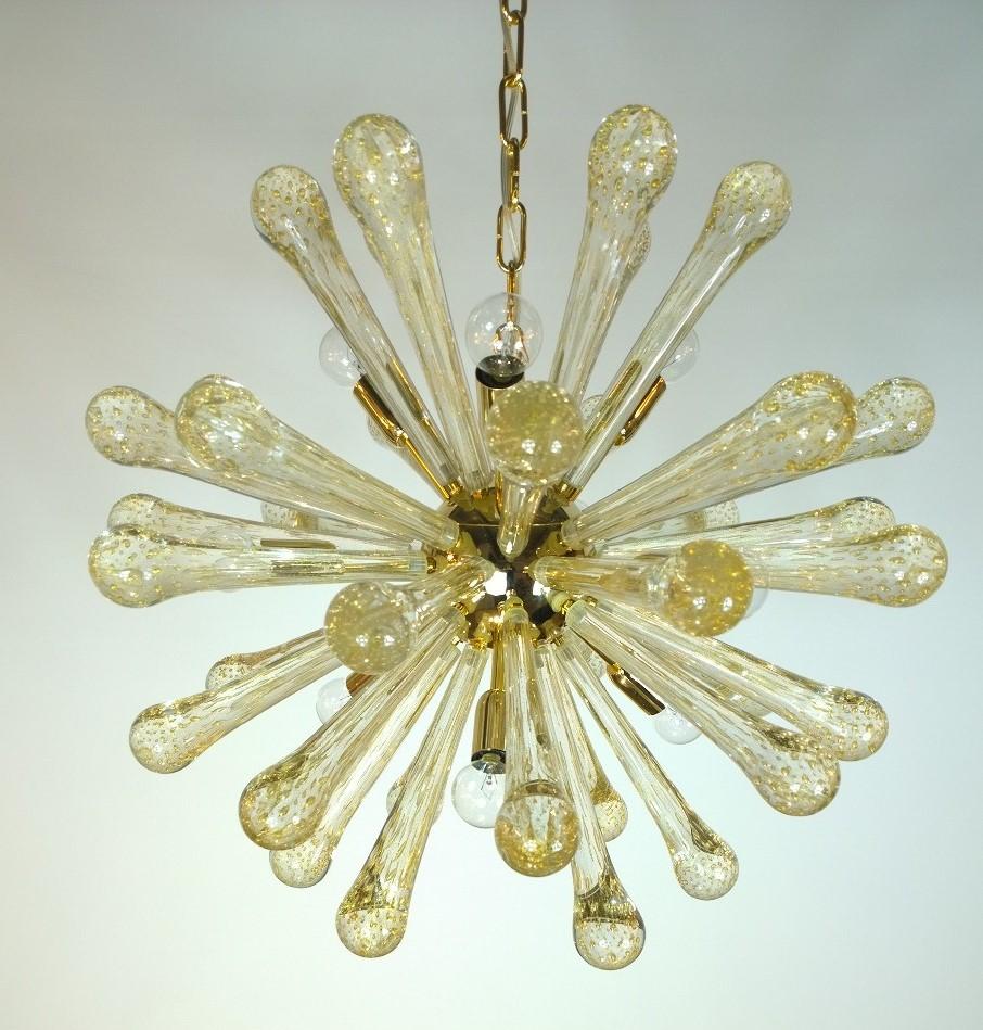 Offered is a late 20th century Italian gold flecked clear murano blown glass and brass-plated Sputnik chandelier. Absolutely stunning and brimming with elegance and sophistication. Would look fabulous in any setting. The shiny brass base and gold