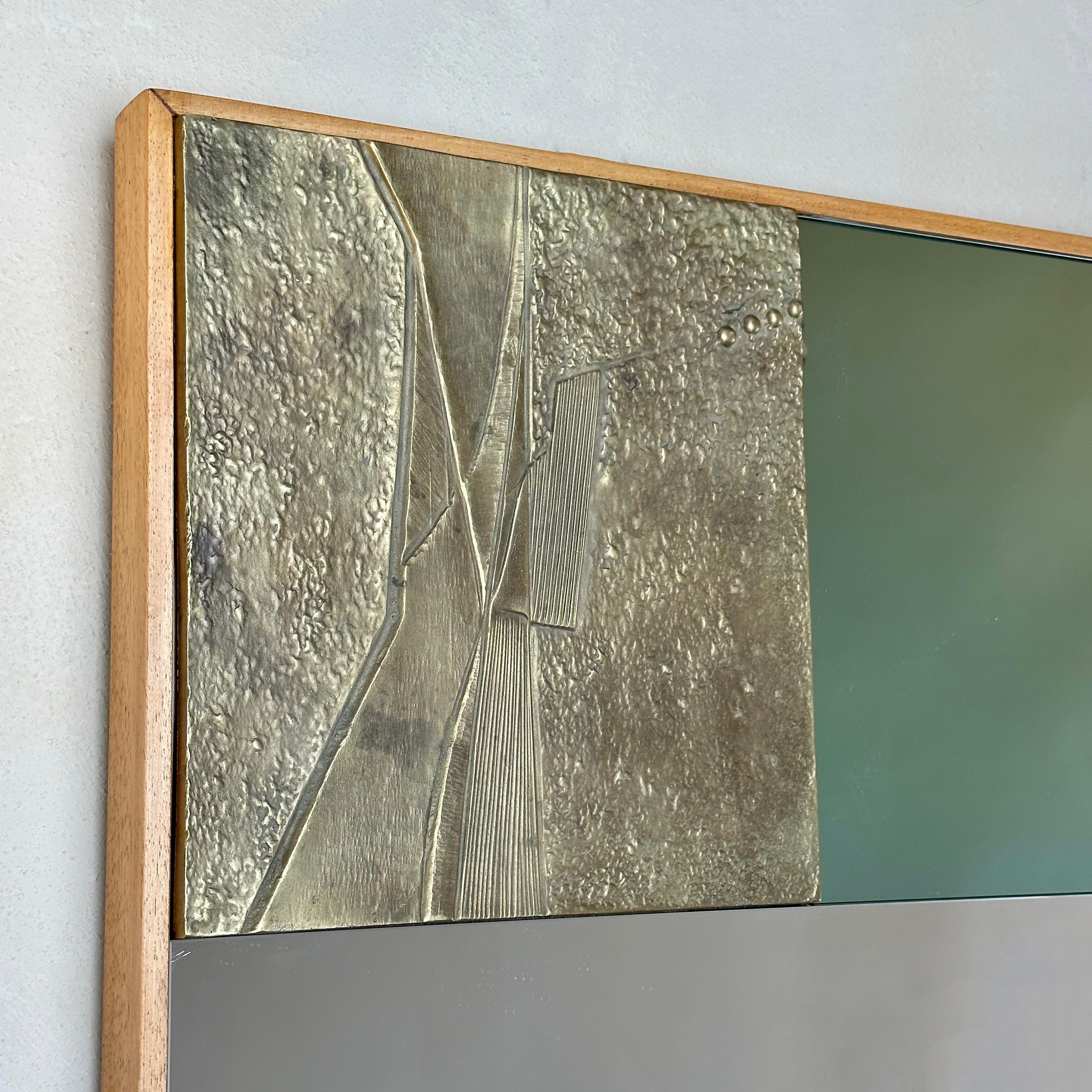 Atemberaubender zweifarbiger Spiegel mit skulpturalen Bronzeplaketten mit abstrakten Motiven und Buchenholzrahmen. Es soll nur waagerecht aufgehängt werden.