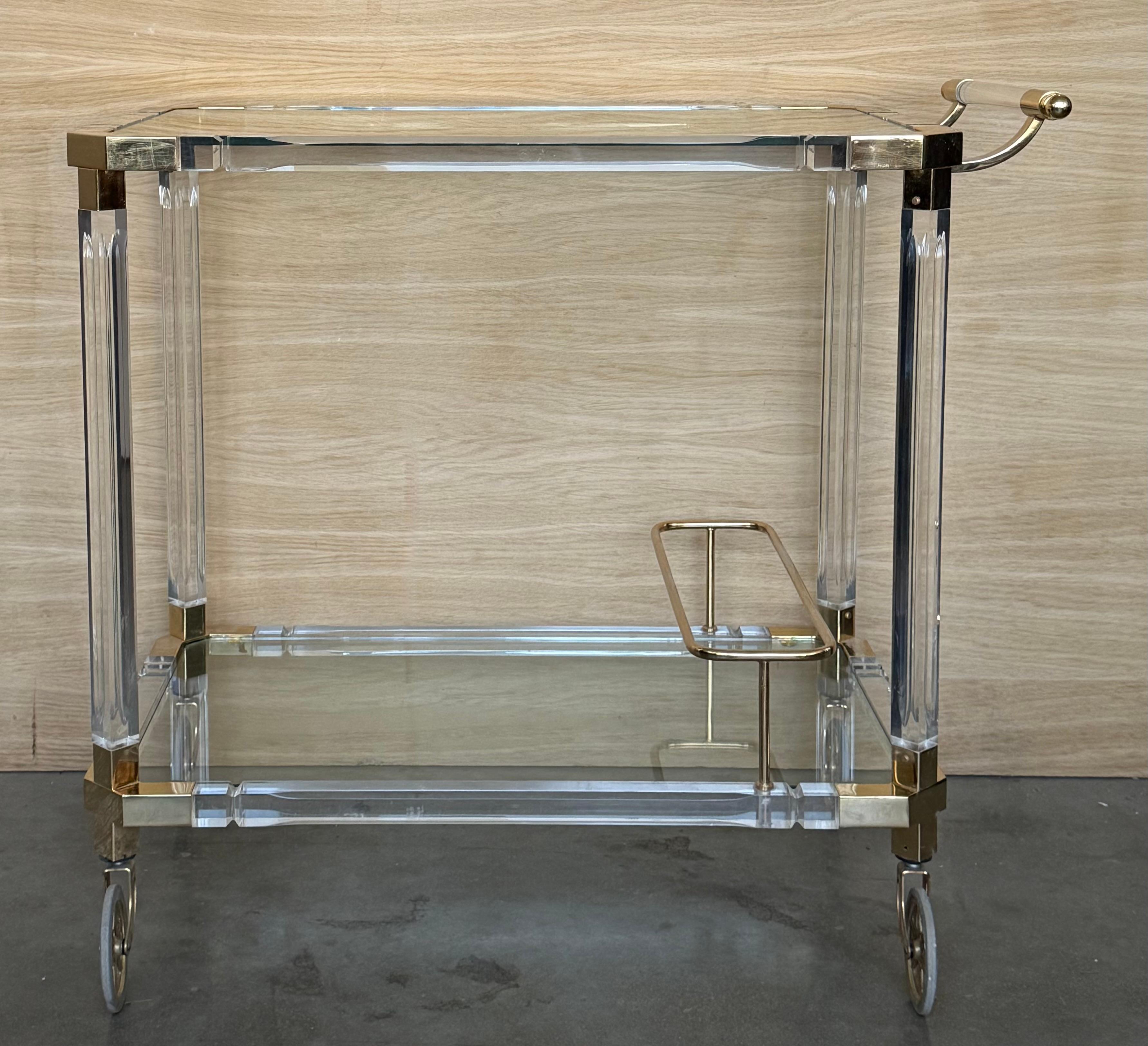 Questo elegante carrello da bar italiano vintage degli anni '1960 incarna il glamour e la raffinatezza dell'estetica Hollywood Regency. Progettato con una silhouette scultorea, combina armoniosamente materiali luminosi per creare una presenza