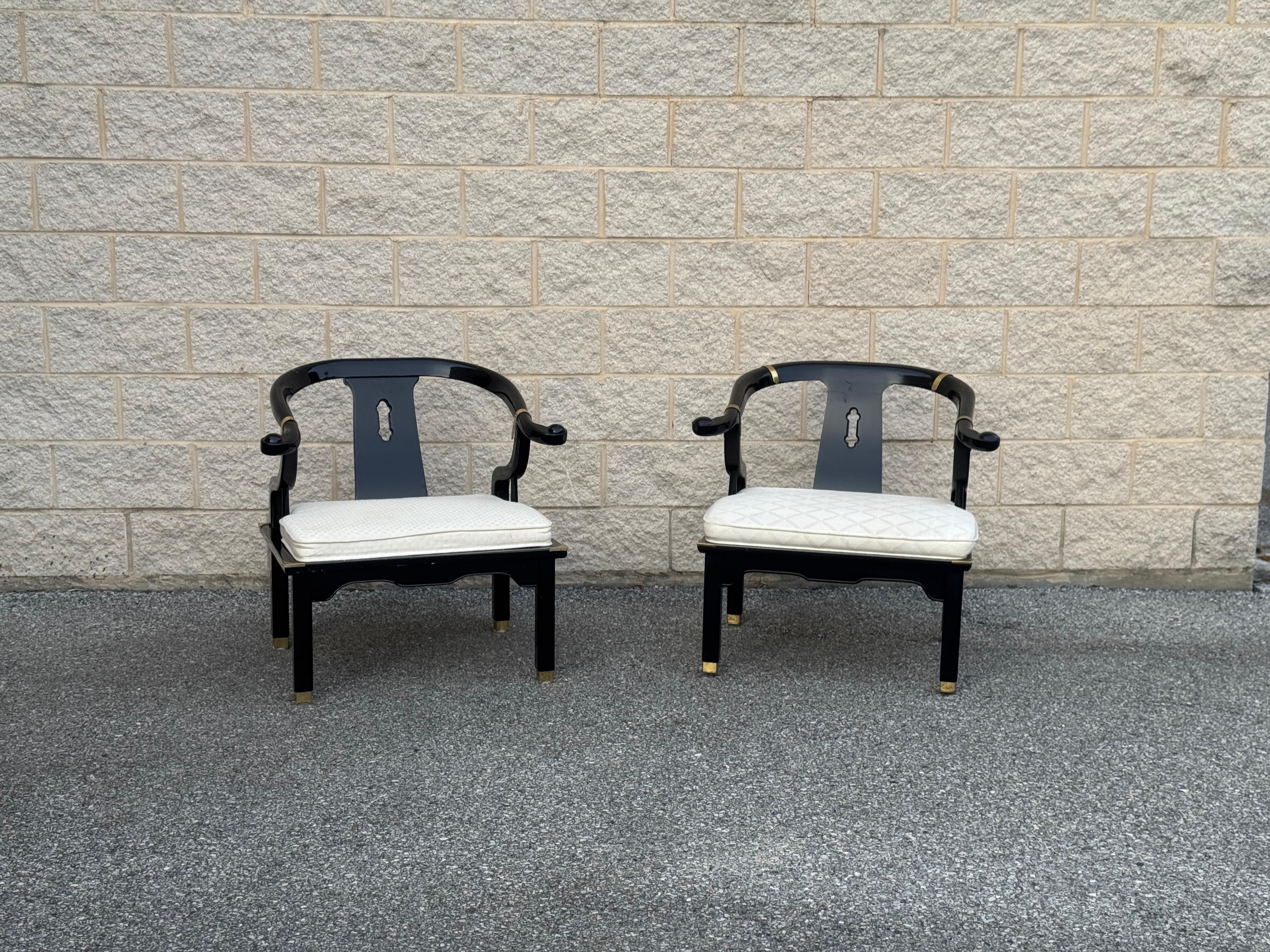 James Mont's Century Ming Style Horseshoe Chairs feature a solid wood frame with a high gloss lacquer finish. The design includes a carved backrest and distinctive horseshoe-shaped arms. 