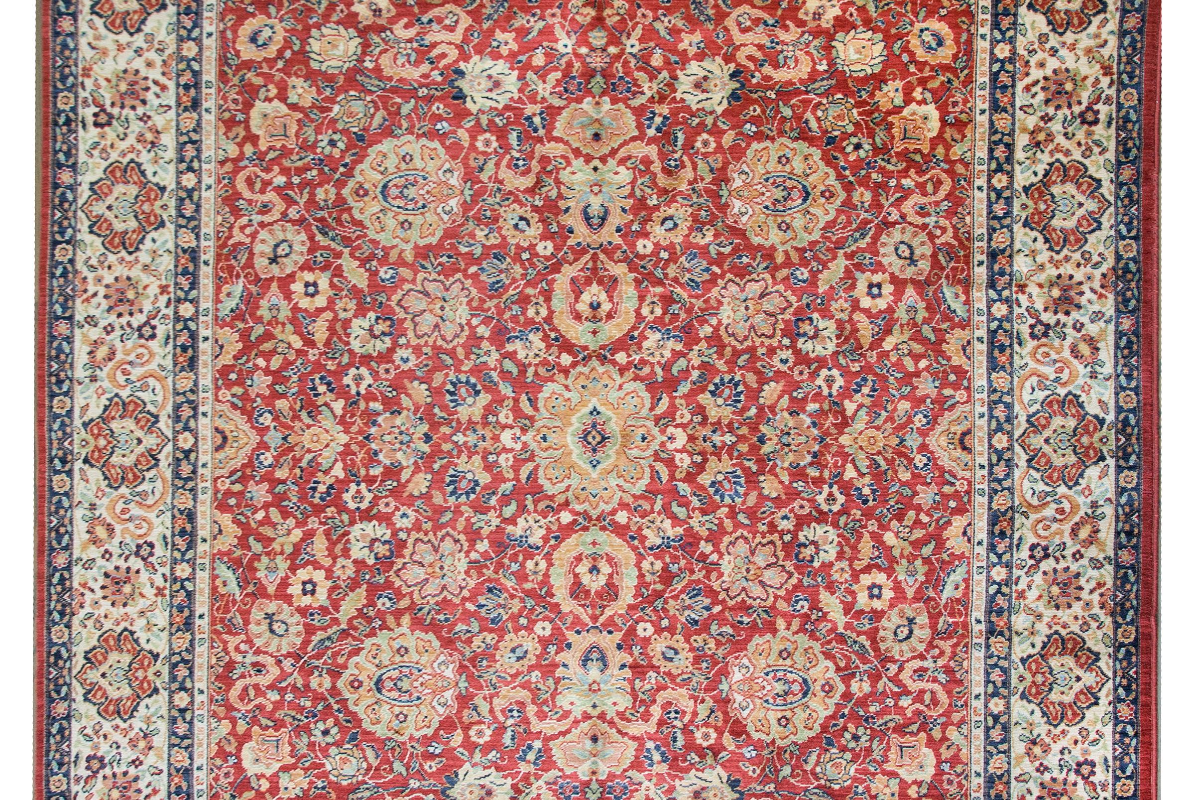 A beautiful late 20th century Karastan rug hand-knotted with a Mahal pattern containing a large mirrored stylized floral and scrolling vine pattern surrounded by a wide border with a repeated floral pattern flanked by pairs of thin petite floral