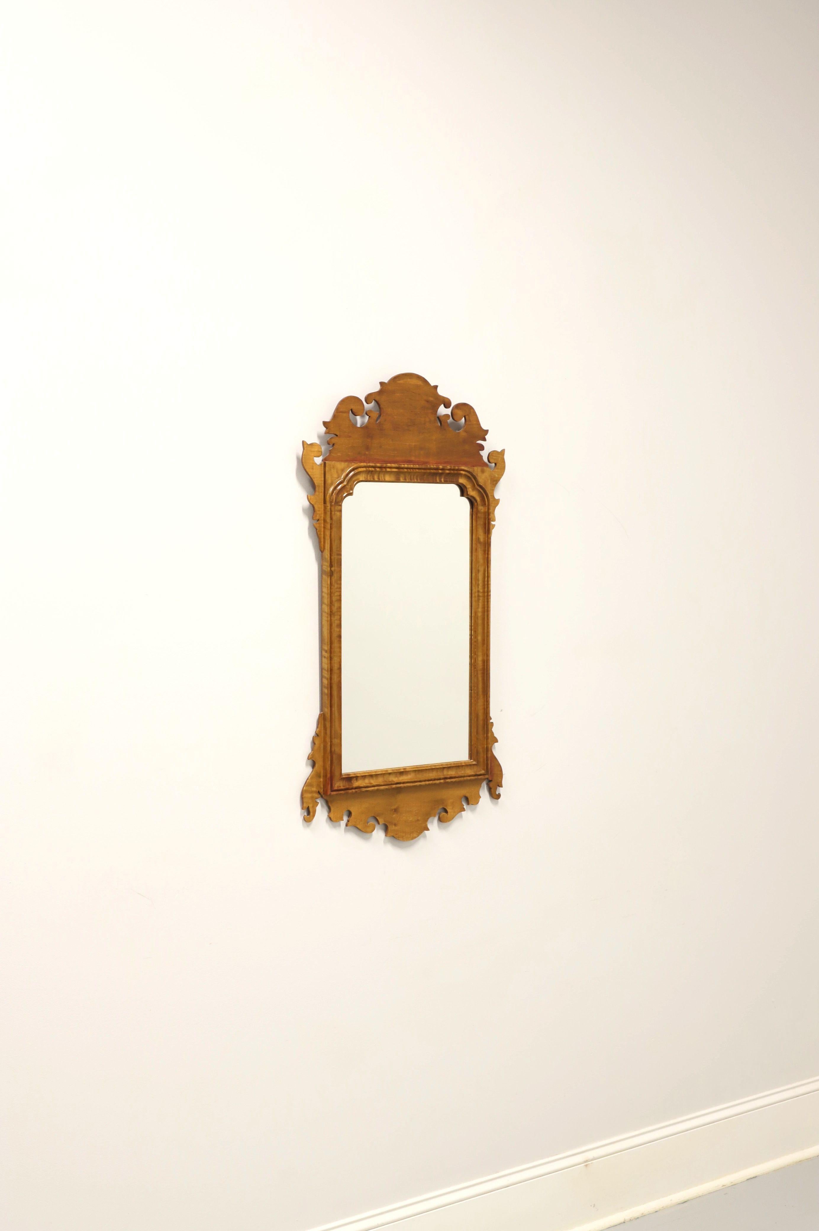 A Chippendale style wall mirror, unbranded. Mirror glass in a tiger maple frame with a light color finish, decorative carving to top & bottom, and carved wood bevel surrounding mirror glass. Made in the USA, in the mid 20th Century.

Measures: