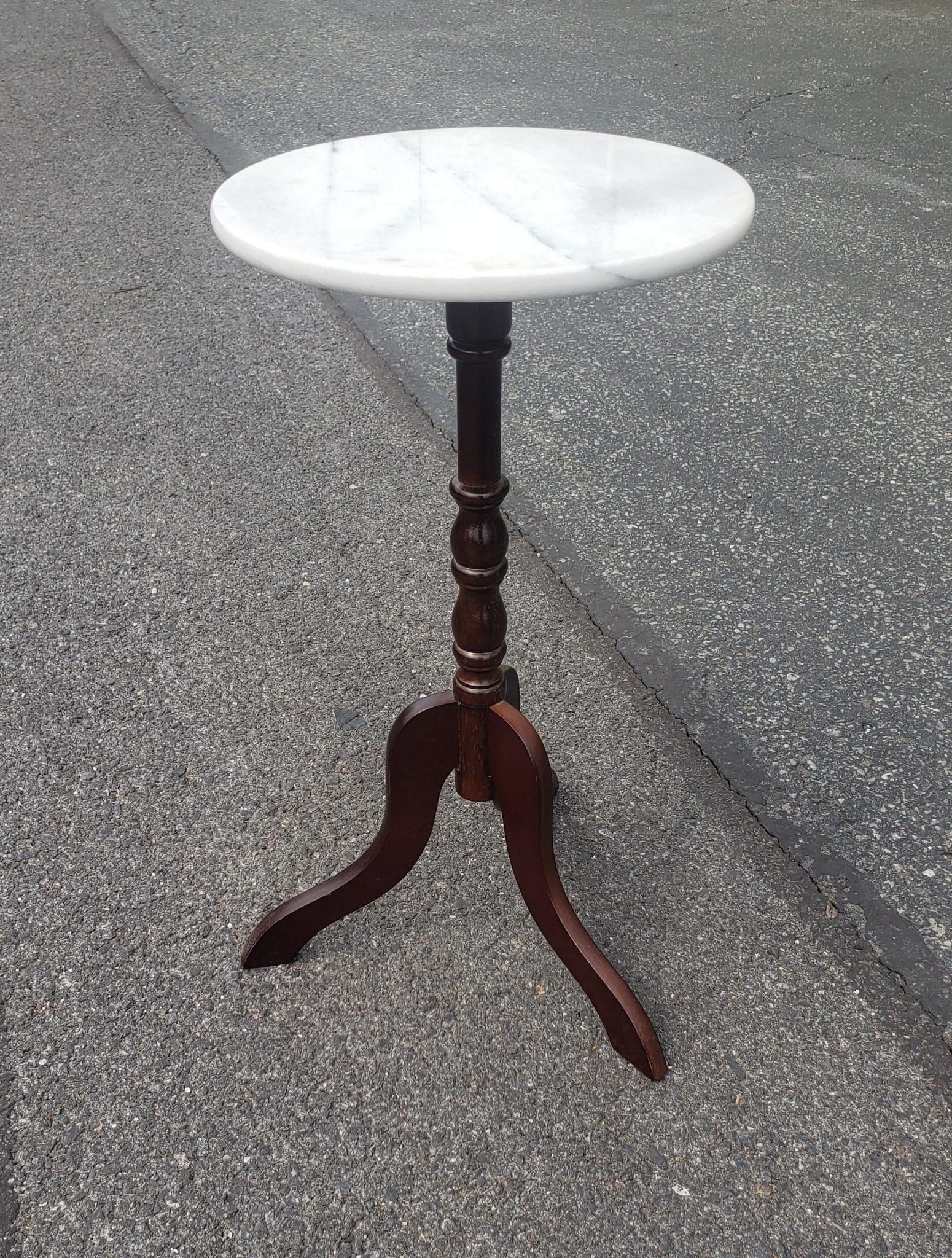 A mahogany pedestal Tripod stand with round marble top. Measure 12