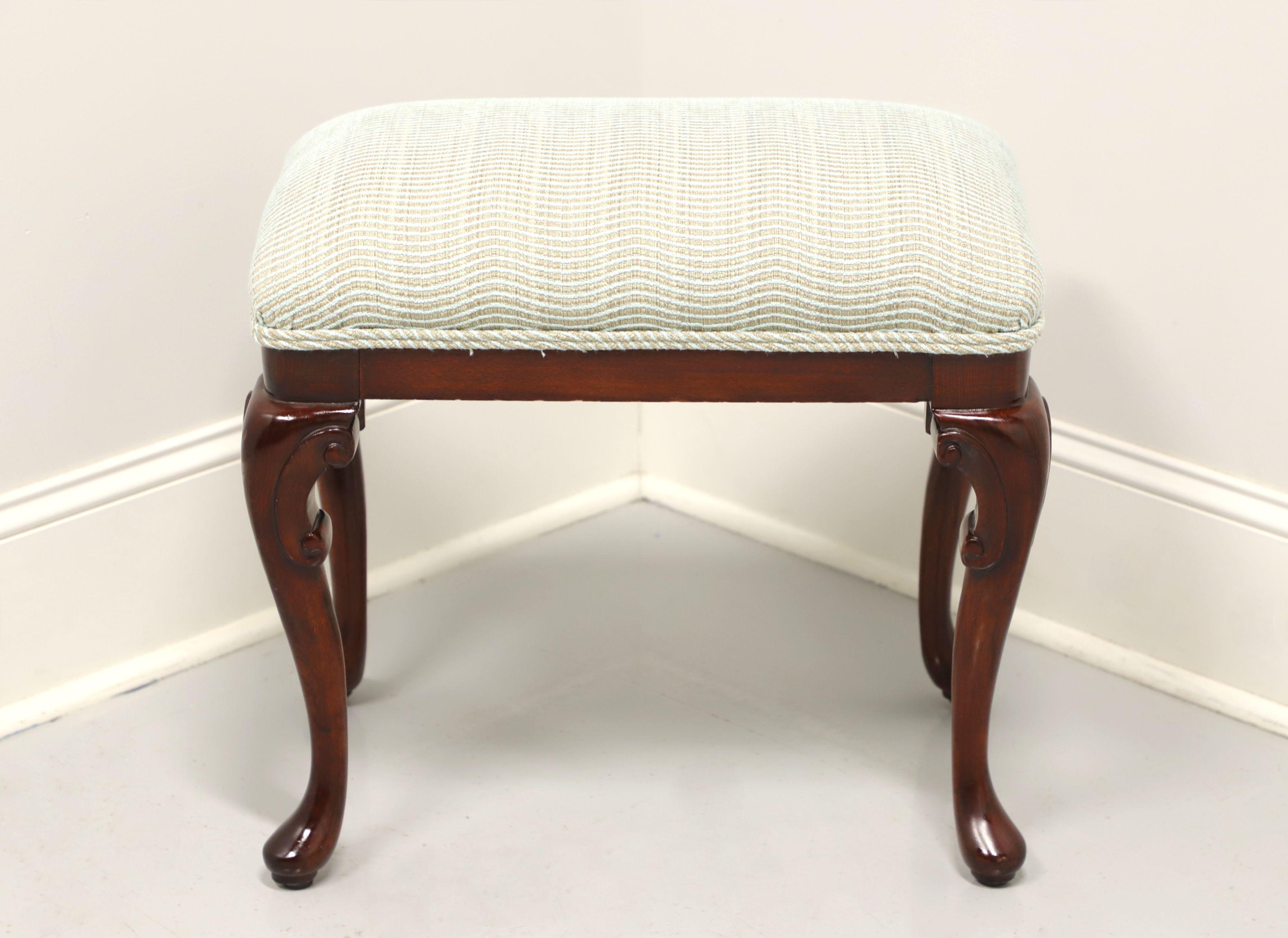 A Queen Anne style bench / footstool, unbranded, similar in quality to Ethan Allen. Solid mahogany with carved knees, cabriole legs and pad feet. Features a light blue tweed like fabric upholstered seat. Made in the USA, in the late 20th