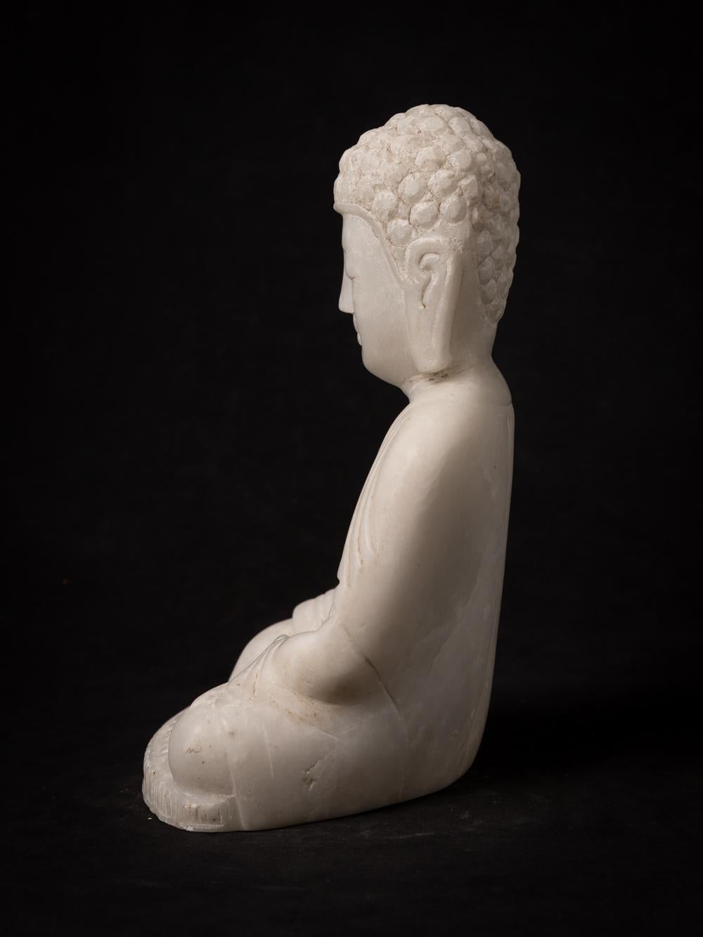 This elegant Marble Buddha statue, portraying the Bhumisparsha mudra, is a work of art that stands at 28.5 cm in height, with dimensions of 19.4 cm in width and 14.3 cm in depth. Carved by hand from a single block of white marble, it represents a