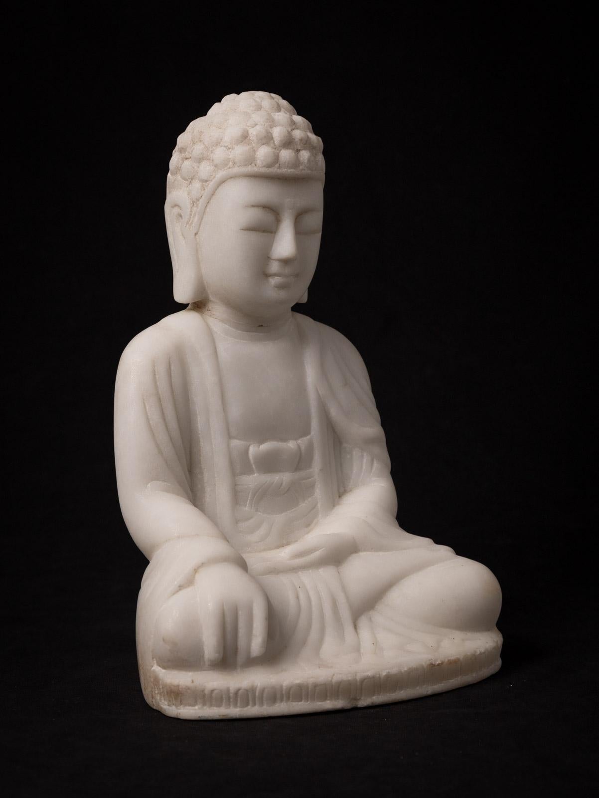 This elegant Marble Buddha statue, portraying the Bhumisparsha mudra, is a work of art that stands at 29,3 cm in height, with dimensions of 19,3 cm in width and 15,3 cm in depth. Carved by hand from a single block of white marble, it represents a