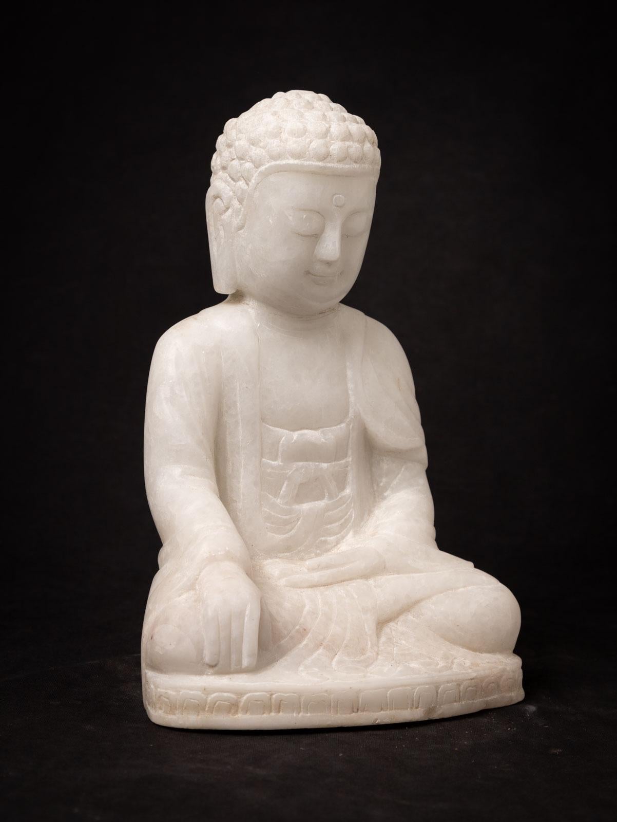 This elegant Old marble Buddha statue, portraying the Bhumisparsha mudra, is a work of art that stands at 29,5 cm in height, with dimensions of 19,4 cm in width and 15,8 cm in depth. Carved by hand from a single block of white marble, it represents