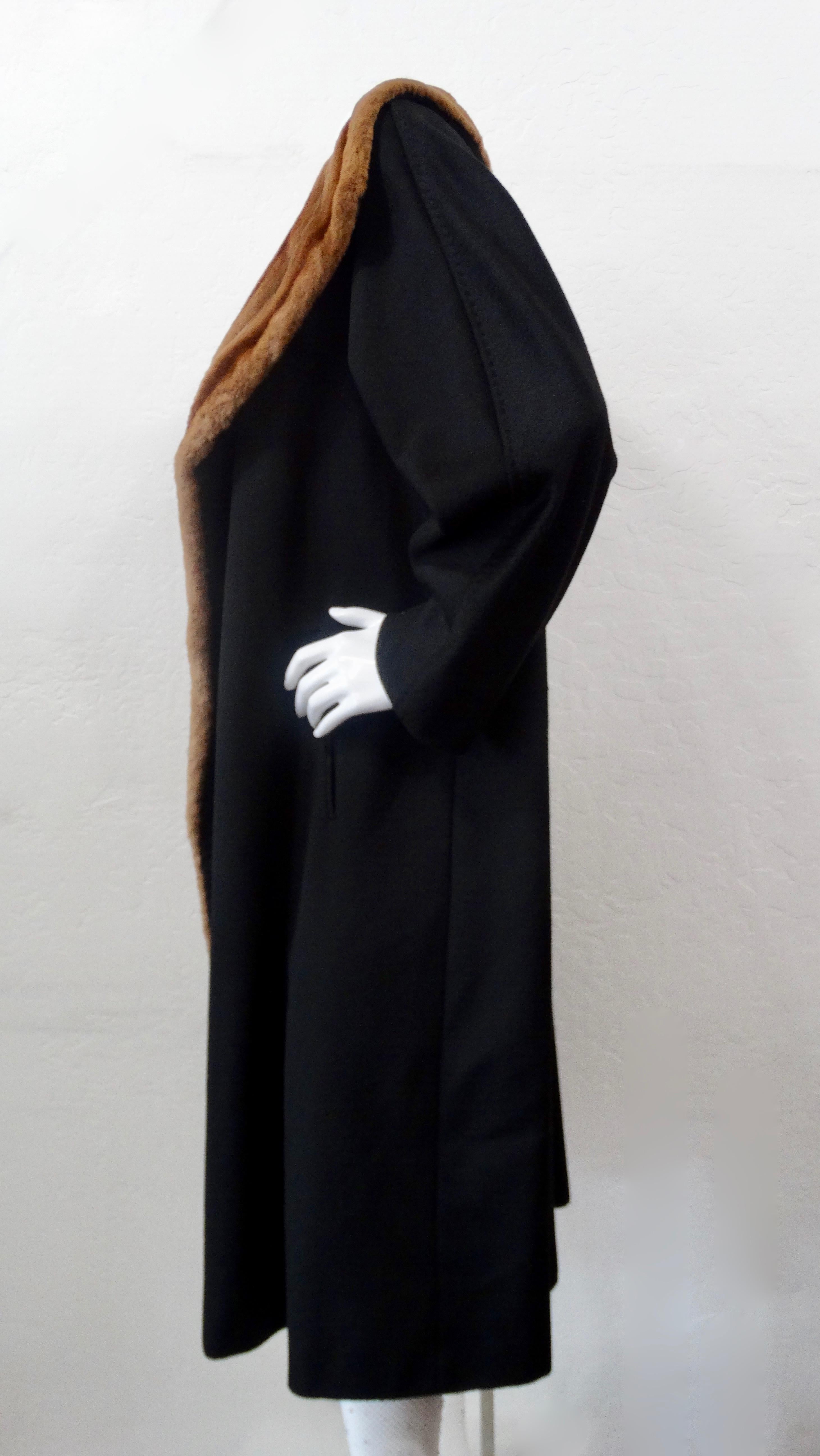 Stay warm and Oh-so stylish with this MaxMara coat! Circa late 20th century, this coat is crafted from black cashmere and features a soft mink fur shawl collar. Includes side slit pockets and a button for a cape look. Chic and timeless, this coat is