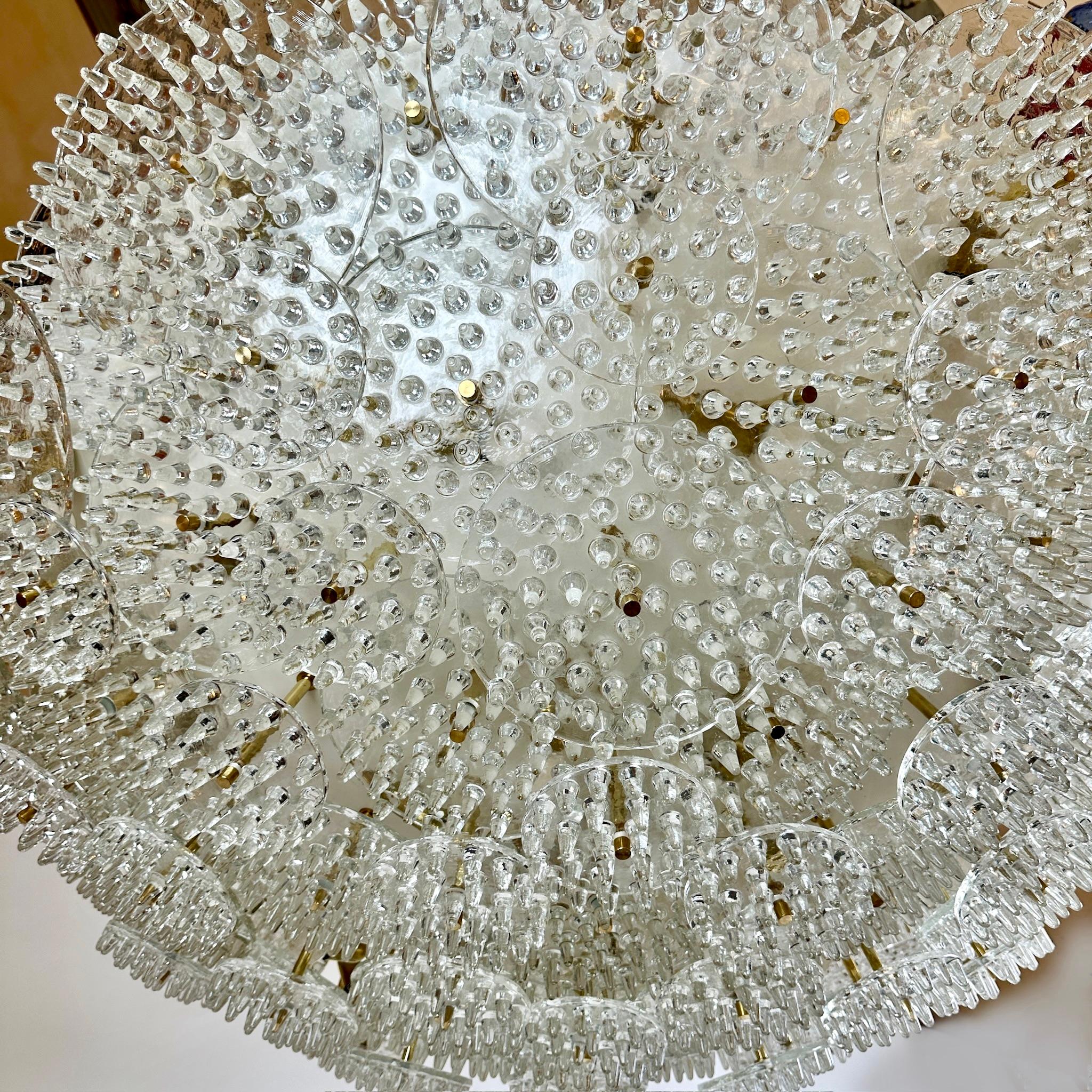 Impressive white metal & brass with three kinds of transparent Murano glass disks full of pinnacles (size: 15, 25 & 30 Diam. cm.) flush mount / chandelier.
Recommended 31 E14 Warm light bulbs.
Approx weight: 180 Kg. 