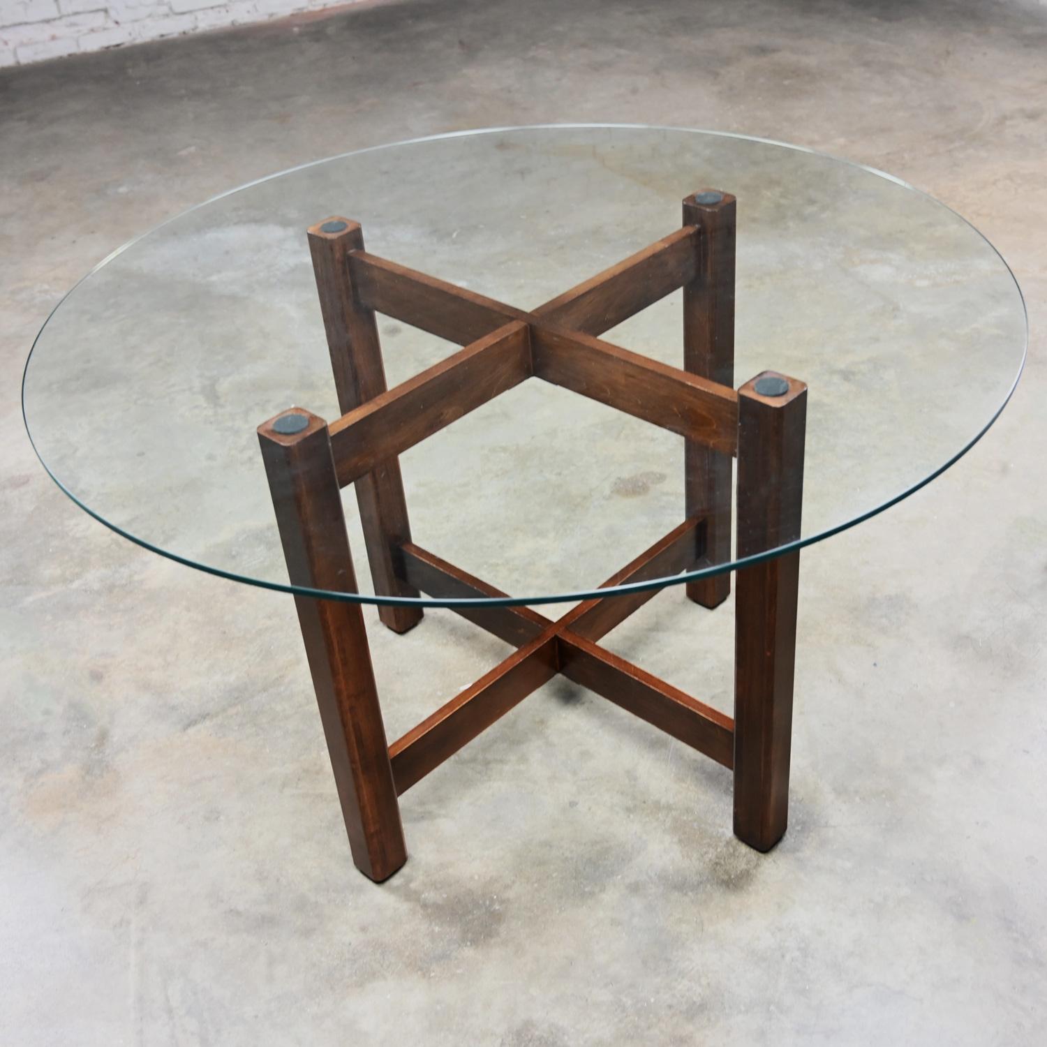 Handsome Late 20th Century Modern walnut X-base dining table with new round tempered glass top with flat polished edge. Beautiful condition, keeping in mind that this is vintage and not new so will have signs of use and wear even if it has been