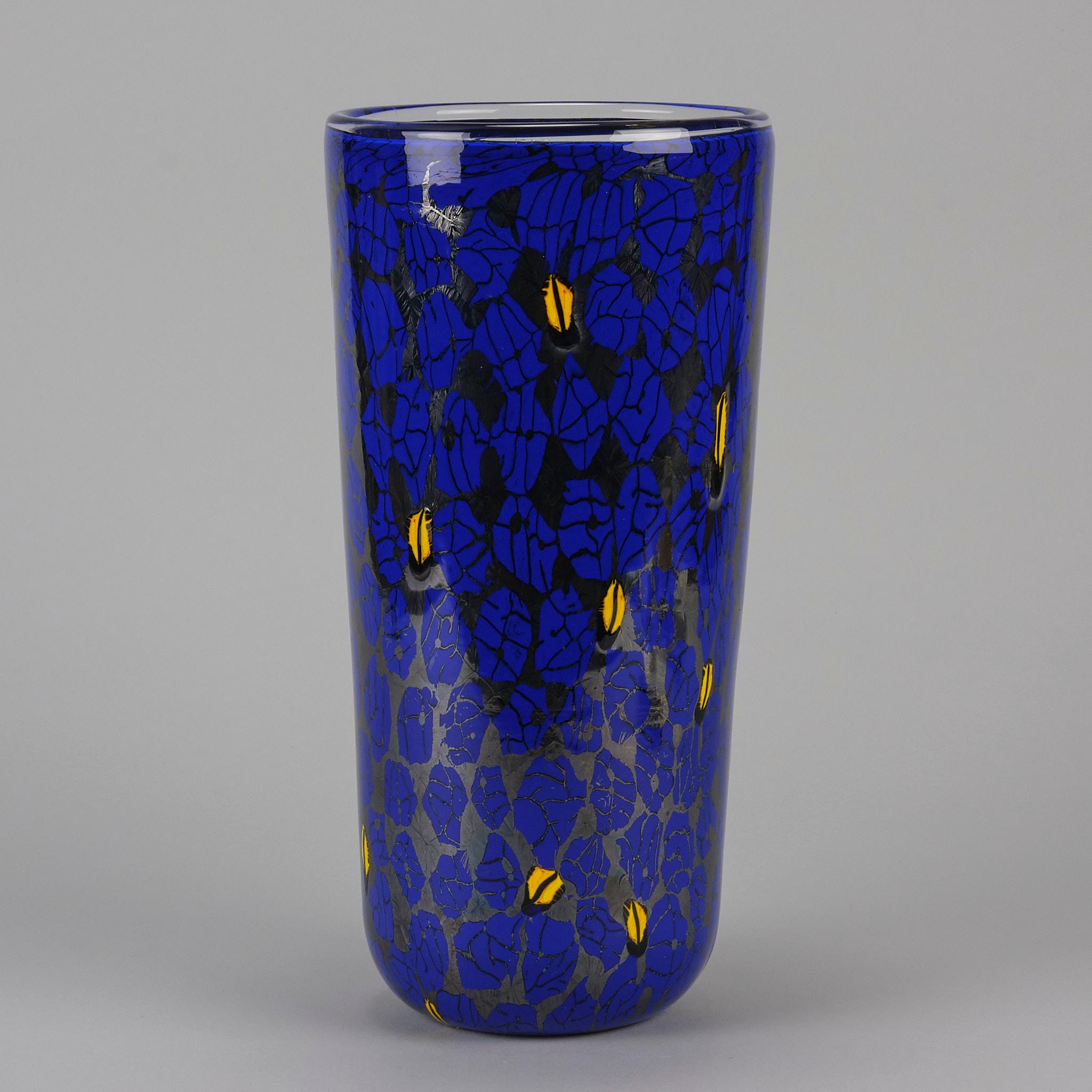 A fabulous Vittorio Ferro clear glass vase with fused marbled murrines in hues of blue and yellow. Marked Ferro Vittorio and with original Murano label

ADDITIONAL INFORMATION
Height:                                      30.5 cm                 