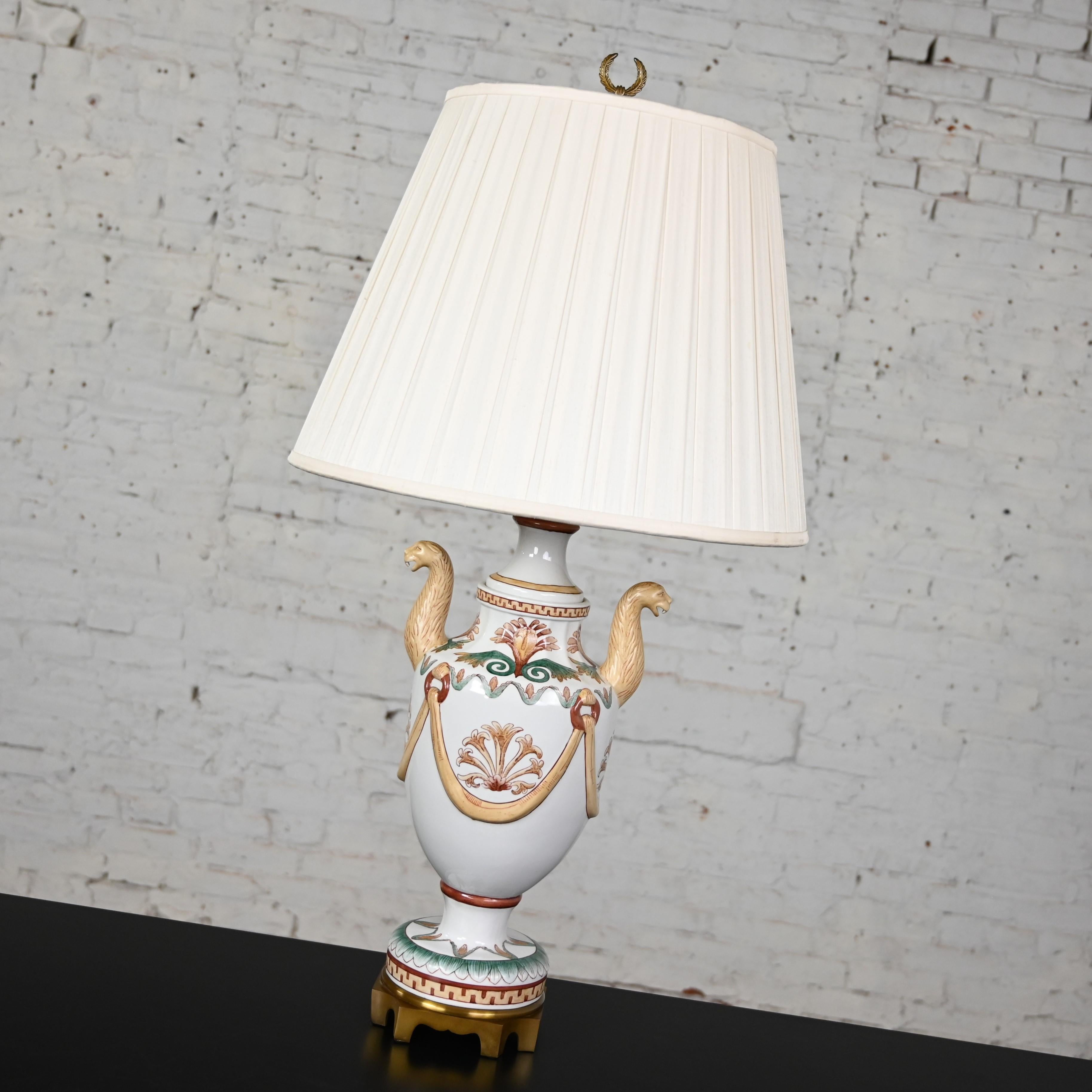 Marvelous vintage Neoclassic Maitland-Smith porcelain lamp with serpentine style lion head details and original off-white pleated fabric hard back shade. Beautiful condition, keeping in mind that this is vintage and not new so will have signs of use