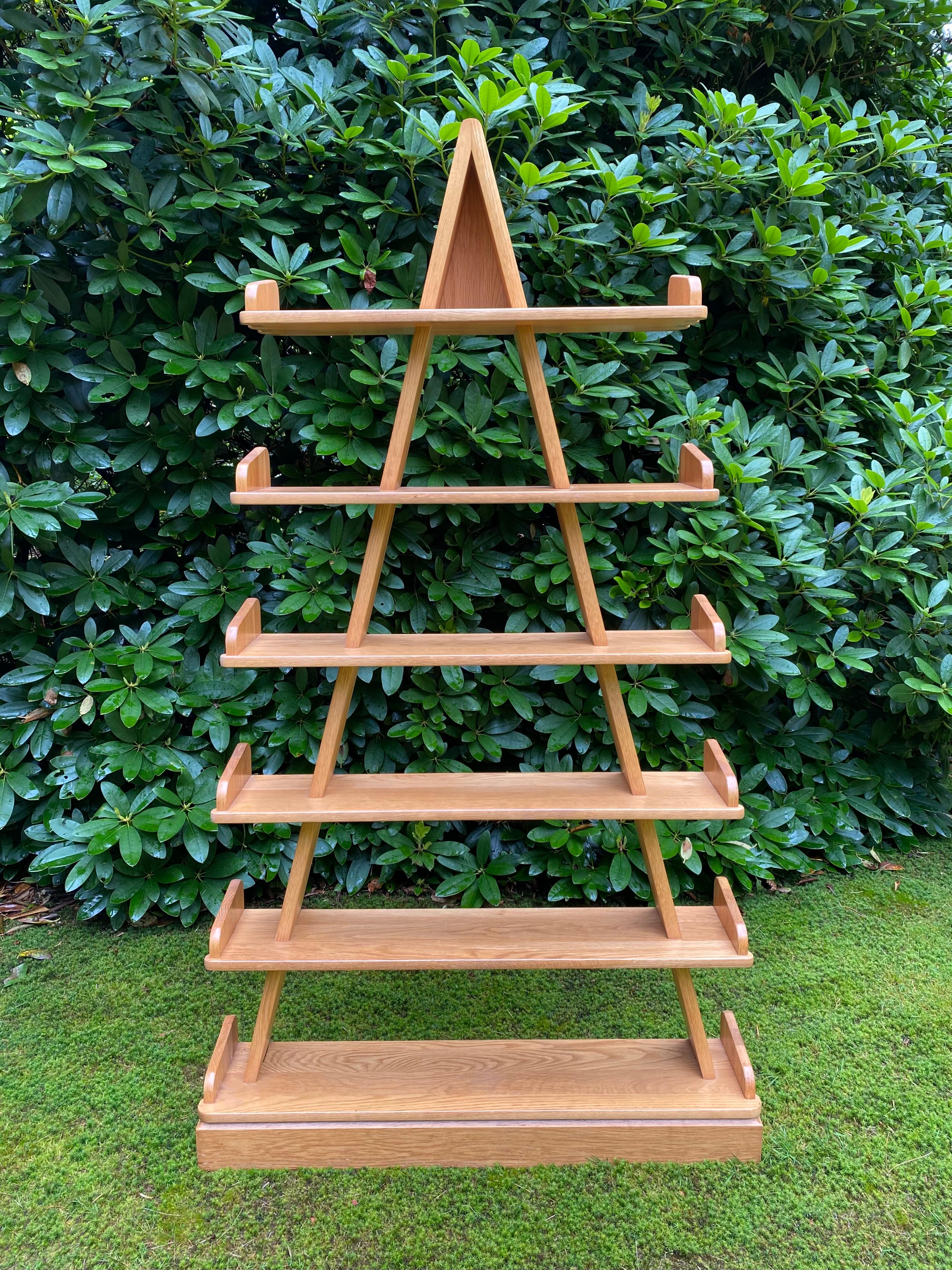 Stunning piece manufactured in Europe, The Netherlands ca. 1980s. This Piramide Shaped Bookcase was made from solid Oak. The unknown designer was clearly inspired by The typical Memphis style forms.
This piece remains in wondeful condition with