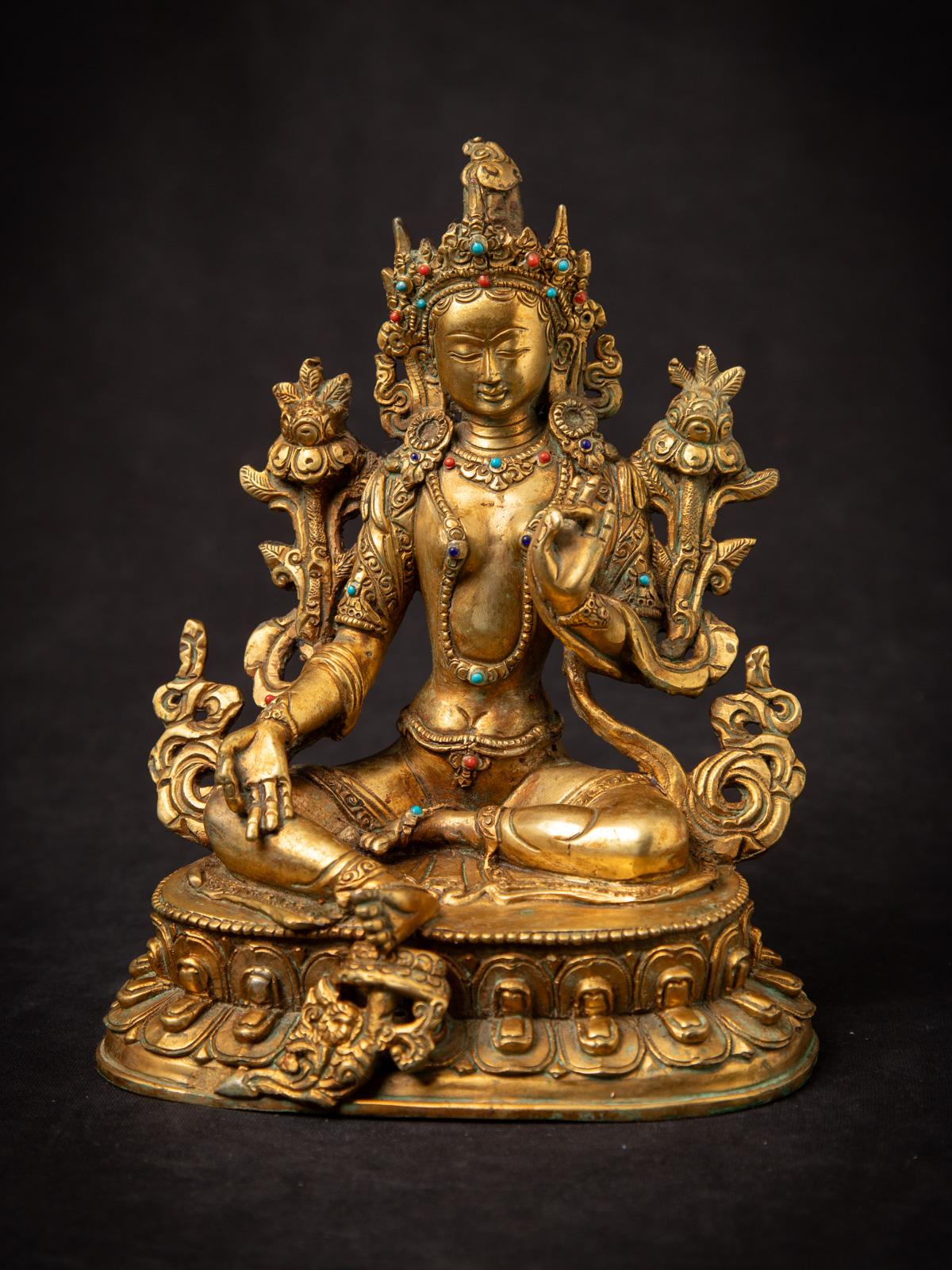 Cette exquise statue de Tara verte, réalisée en bronze et rehaussée d'une dorure à l'or fin 24 carats, est un exemple de l'art népalais de la fin du XXe siècle. D'une hauteur de 21,9 cm, la statue représente magnifiquement la Tara verte, une