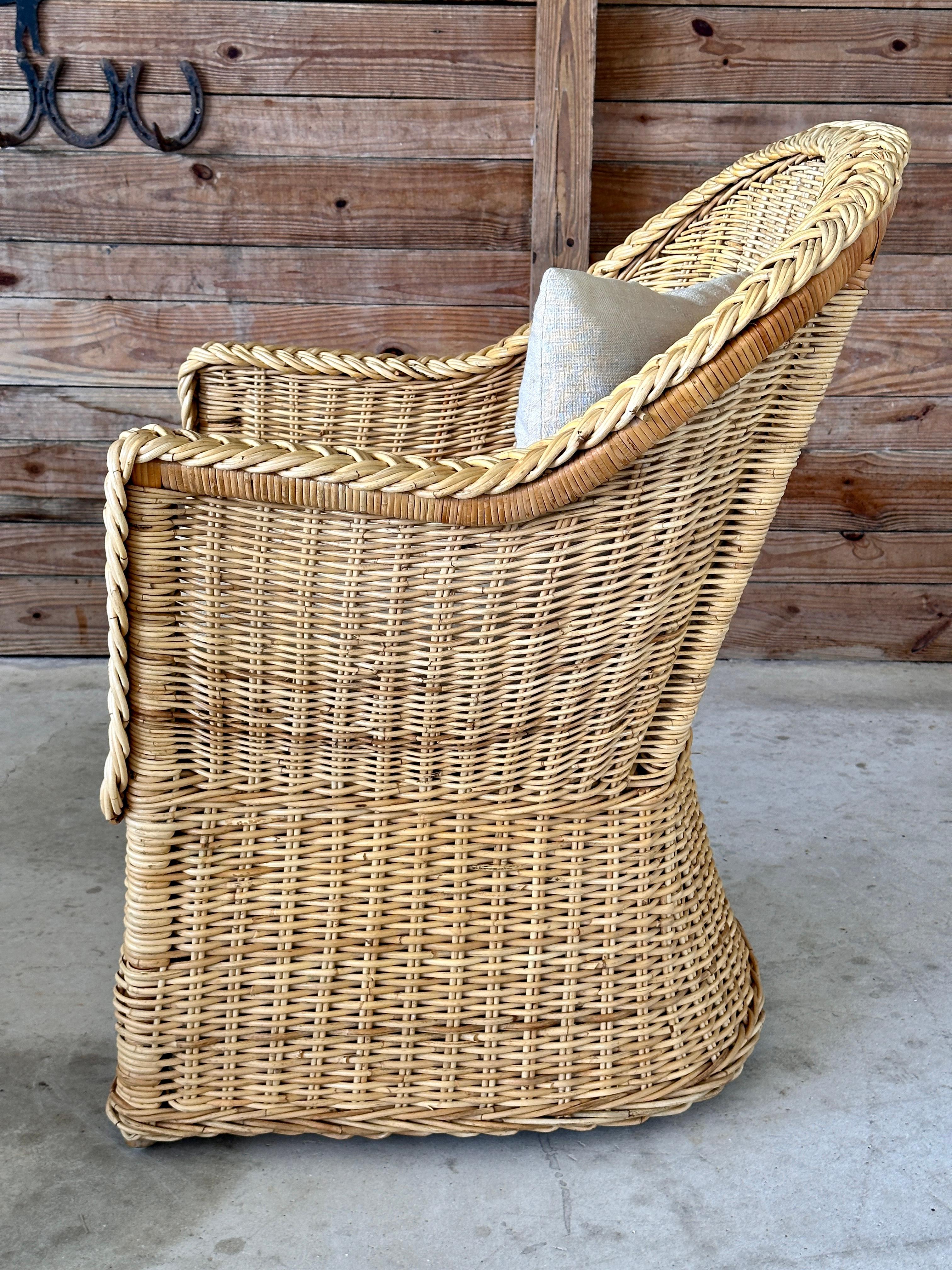 This Late 20th Century large braid rattan side armchair by Wicker Works brings an element of natural texture and coastal elegance to any space.
The robust handwoven braid detail accentuates the curvaceous design of the arms and back, adding a