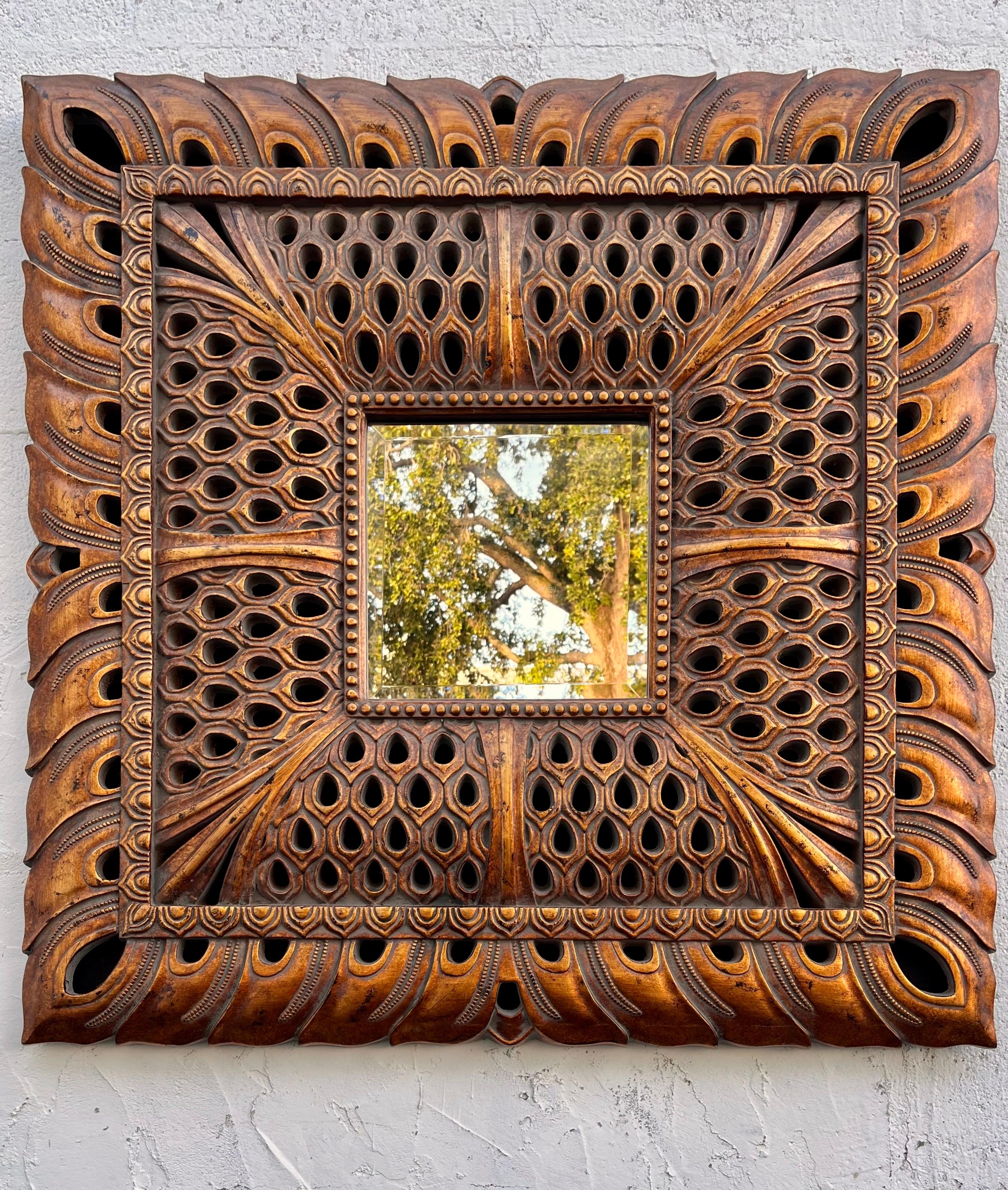 Late 20th century Ornate large scale Resin mirror. Circa 1990s 
Features a large Syroco style frame mimicking Asian inspired carved wood finished with an antique gold patina and a square beveled mirror. 
It can be hung horizontally and vertically.