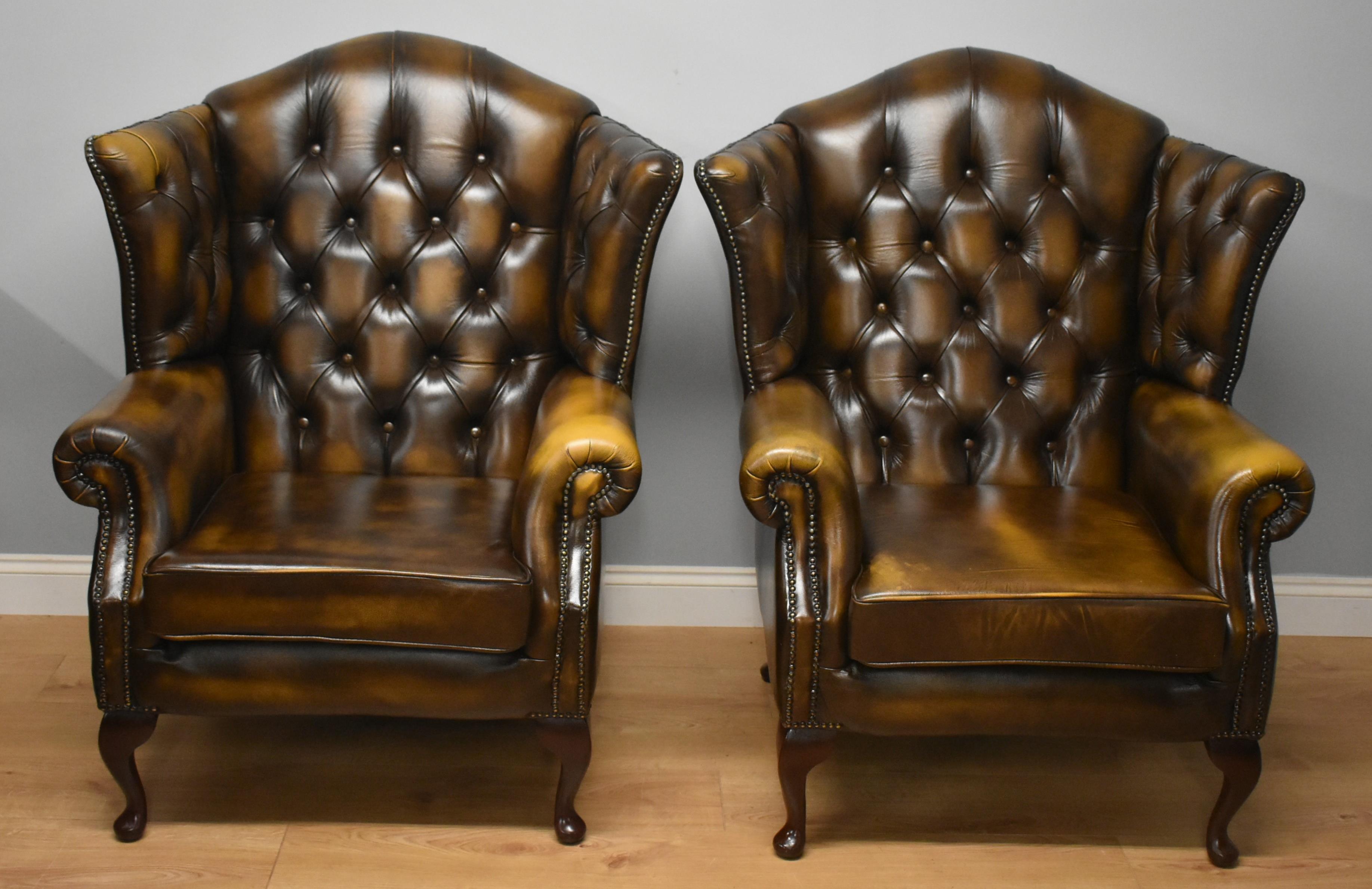 Pair of Chesterfield button back  leather chairs by Thomas Lloyd in very nice condition standing on cabriol legs.