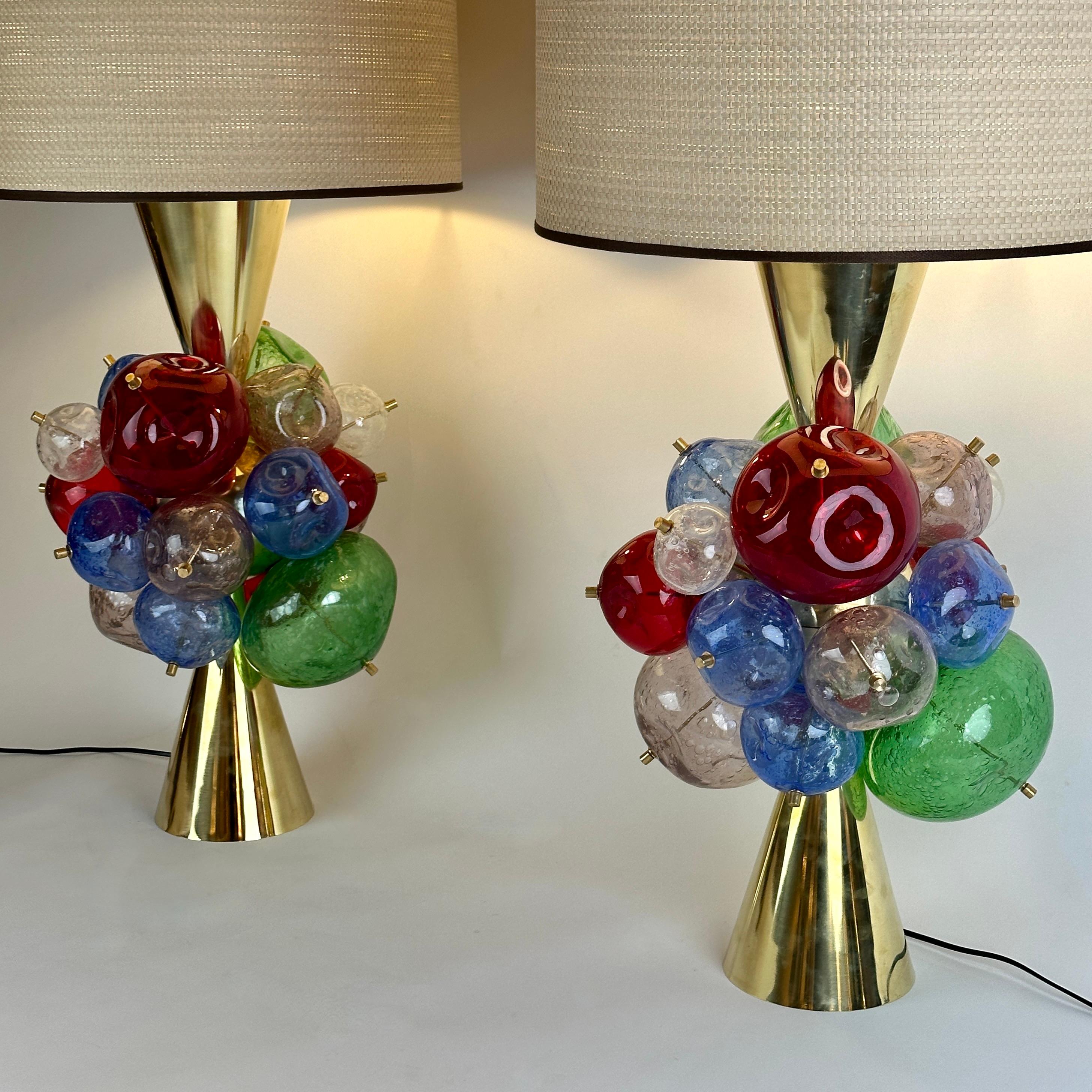Stunning pair of space age brass & multicolored (transparent, red, green, blue and light pink) Pulegoso Murano art glass table lamps. The body of the lamp is made of two cones facing each other with a brass ball in the center from where the crushed