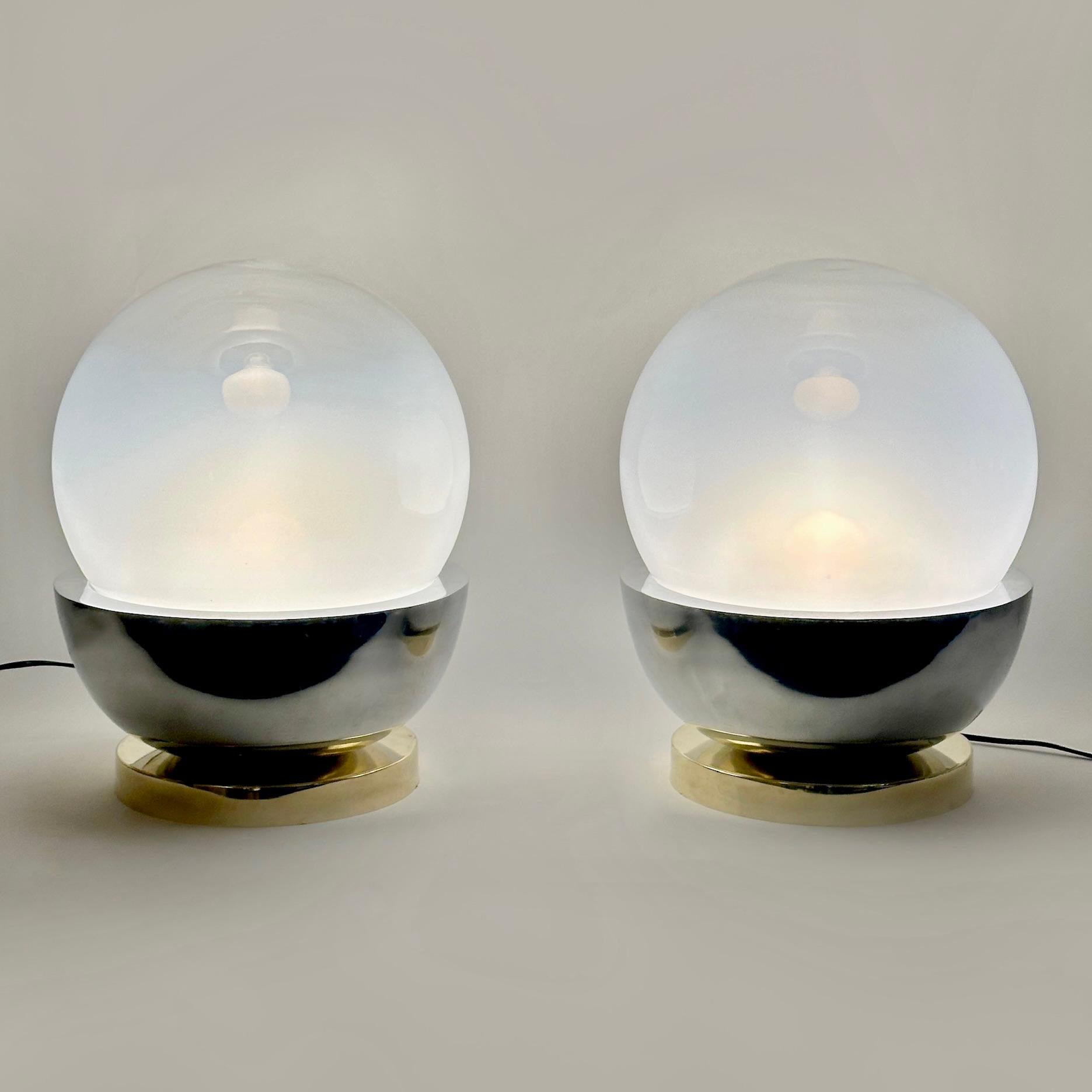 Cette paire de lampes de table classiques s'adapte à presque tous les types d'environnement et est parfaite pour les tables d'appoint de la chambre à coucher.
Le mélange de laiton, d'acier brossé et de verre d'art soufflé de Murano (seul le haut de