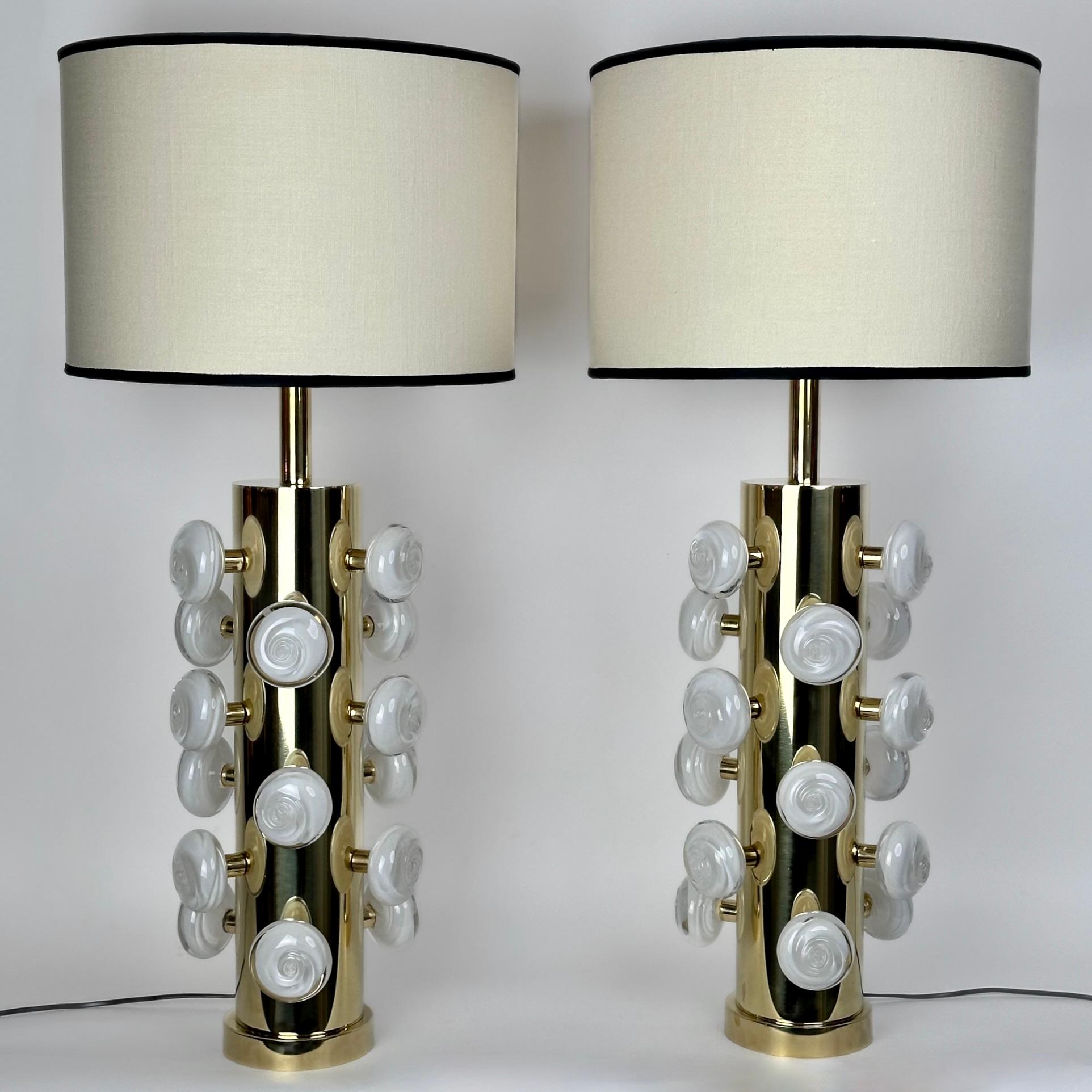 Cette paire de lampes de table modernes en laiton avec des boutons en verre d'art Murano blanc s'adapte à presque tous les types d'environnement.
Le mélange de laiton et de verre blanc de Murano donne à ces lampes une présence forte et rocheuse.