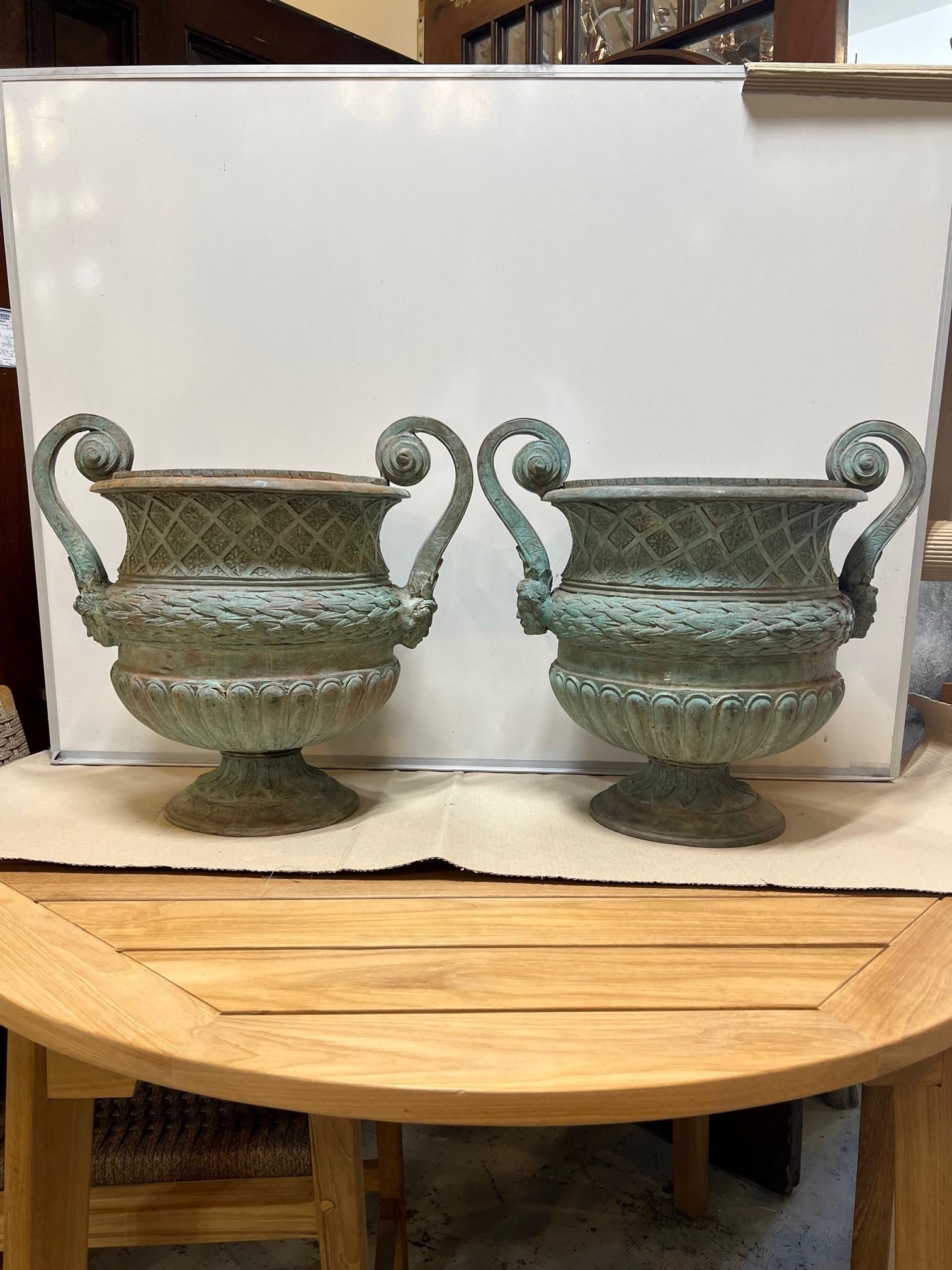 A very nice pair of bronze urns with large handles, intricate detailing and a beautiful Verde patina. Created with the tradition technique of the lost-wax that allows a great precision in the details. This is a great pair of urns good size and price
