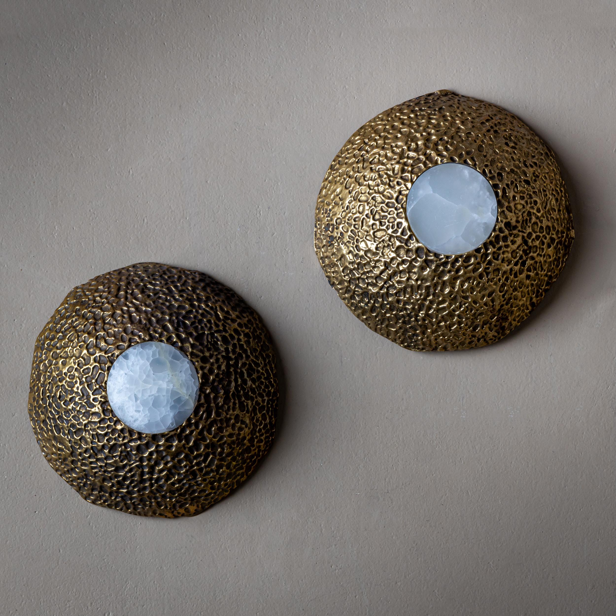 Cette paire d'appliques du fabricant italien Cierre Lampadari de Milan date des années 1960/70. Les corps semi-circulaires sont fabriqués en bronze avec une surface texturée rappelant le corail. Une incrustation d'onyx translucide apporte un