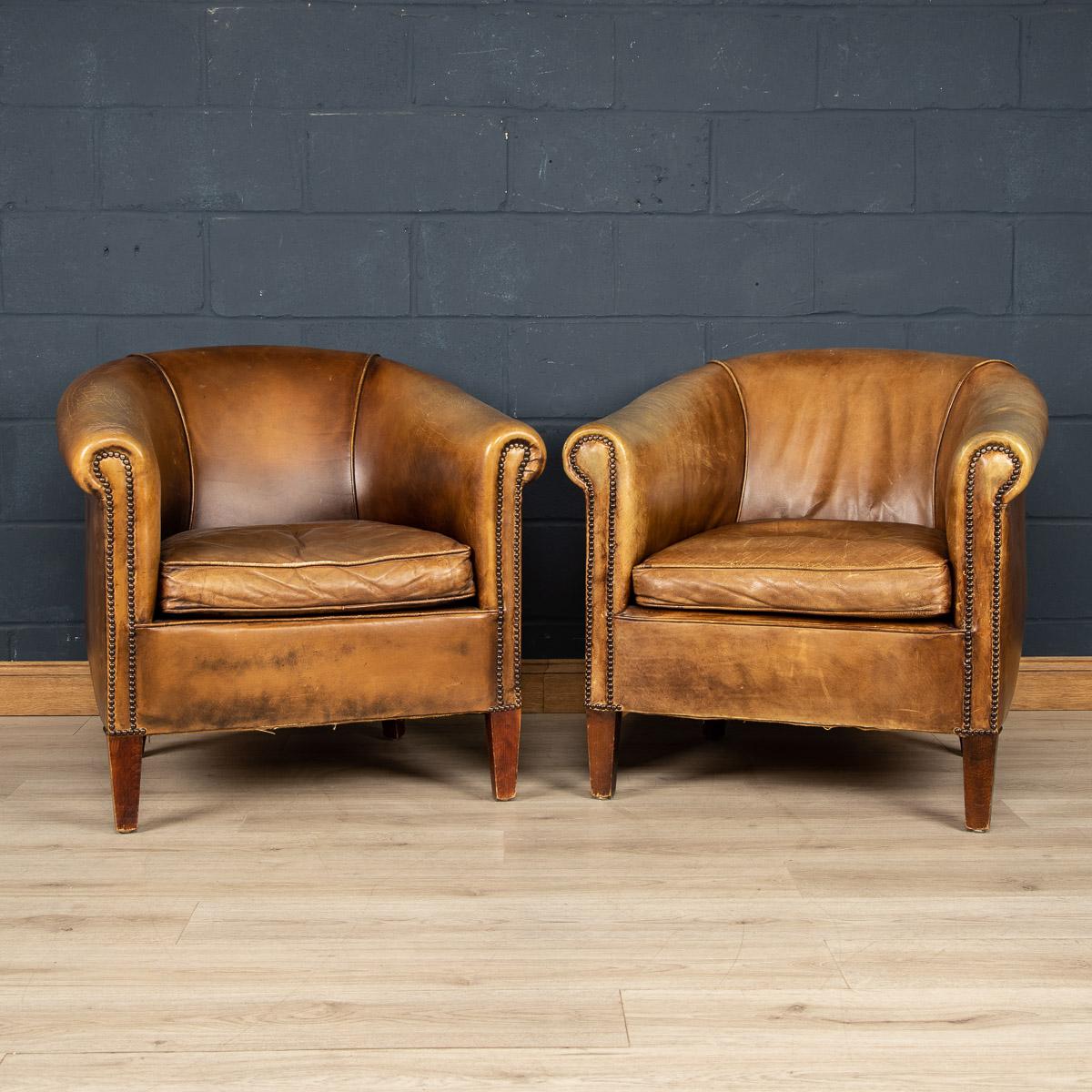 A wonderful pair of leather wing back armchairs. Dating to the latter part of the 20th century these chairs have been realised by the finest Dutch craftsmen, the solid wood frame upholstered in superb quality honey coloured sheepskin leather which