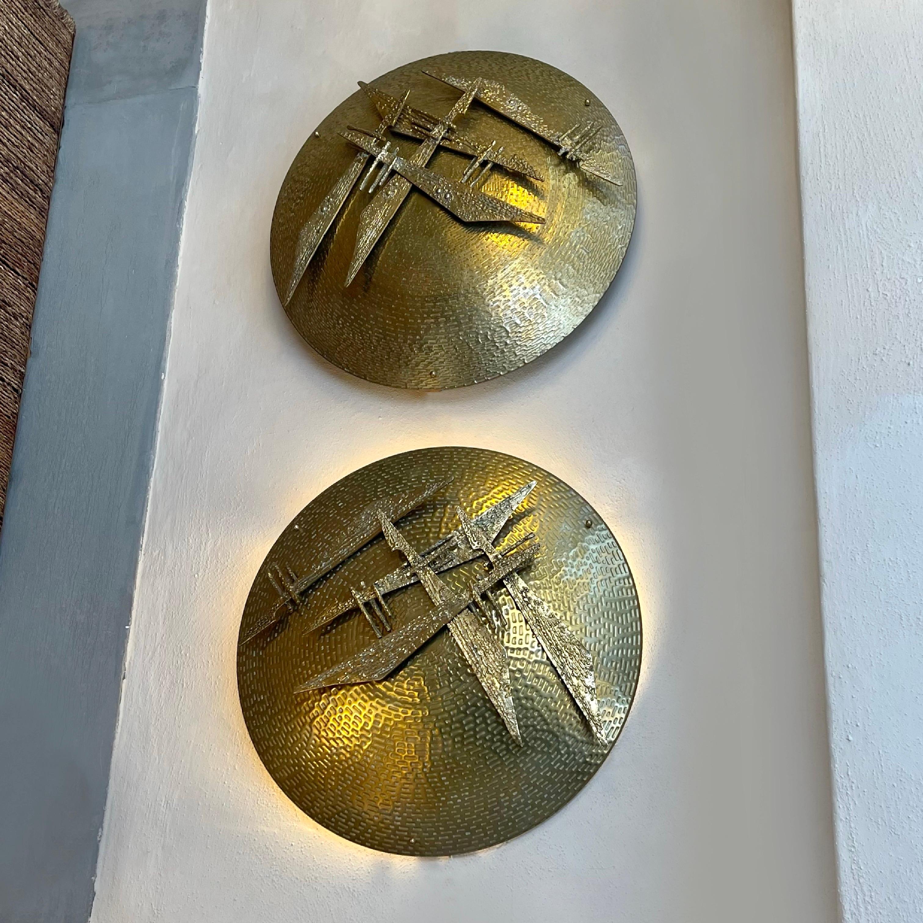 Three E14 light bulbs each.
This pair of sculptural sconces has to be fixed on the wall with spacers in between (two cm. or one inch is enough) in order to allow to the light to go through and make a halo on the back wall.