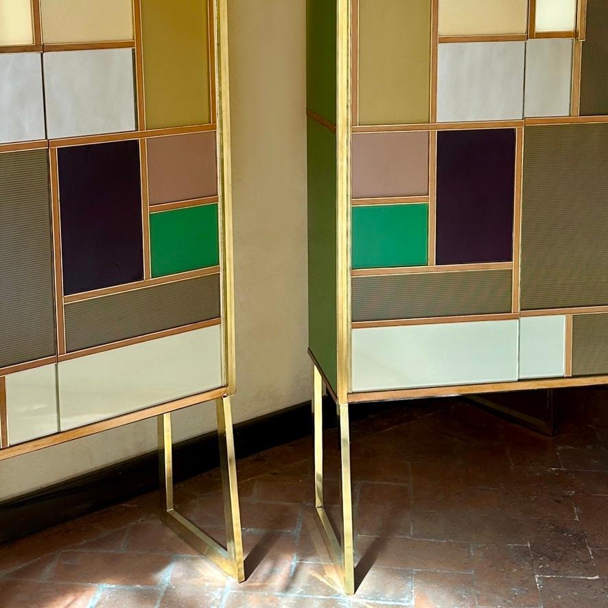 Stunning pair of two doors cabinets with four shelves (85 x 30 cm. each) covered with grey velvet paper and brass details inside. Several color shades of green opaline glass with powder pink, burgundy, beige, off-white, copper mirror and gold metal