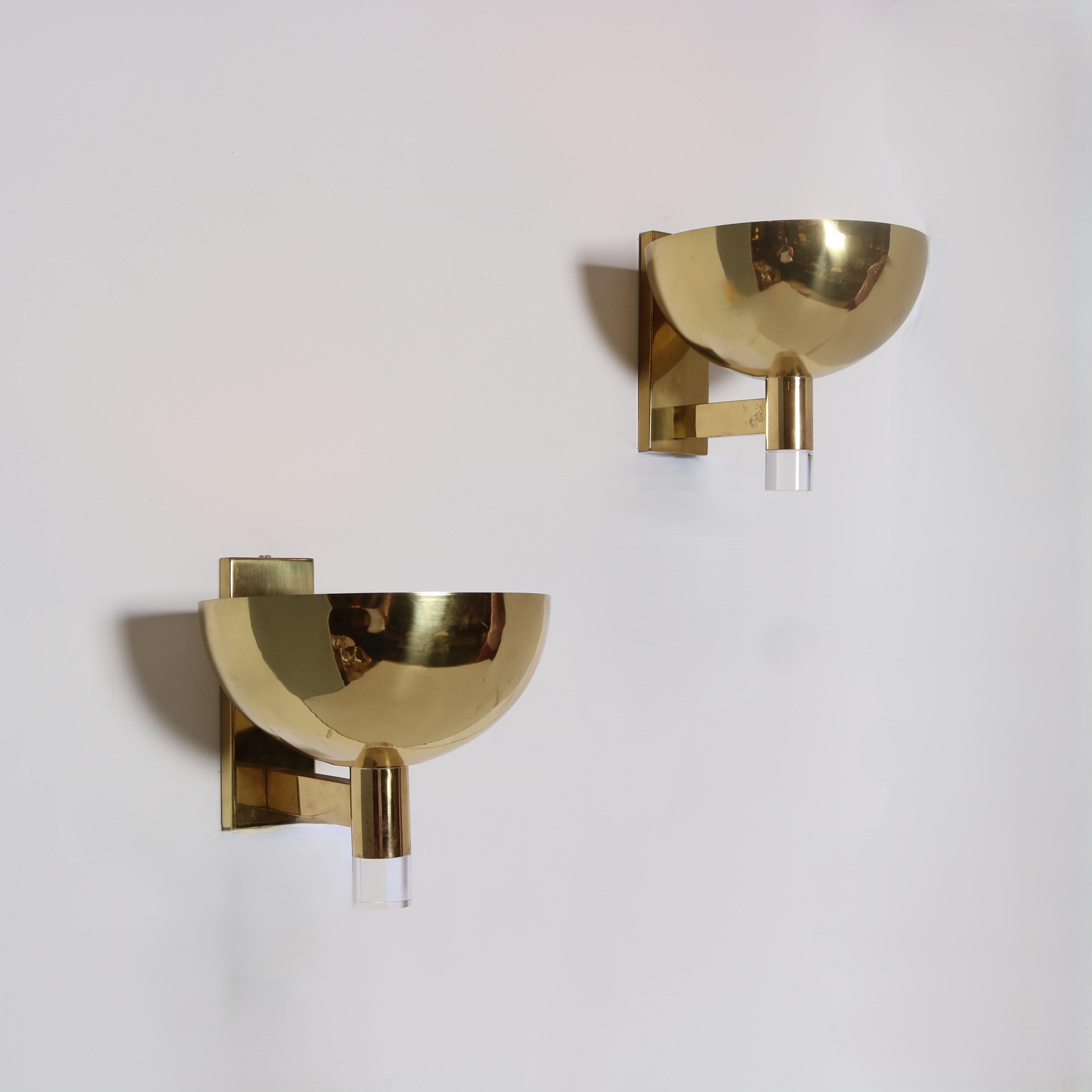 Paire d'appliques en laiton et lucite de grande taille.  Demi-globe en laiton avec un diffuseur à grille en laiton perforé au-dessus de l'ampoule, reposant sur un cylindre en laiton terminé par de l'acrylique.  La lumière brille au-dessus et en