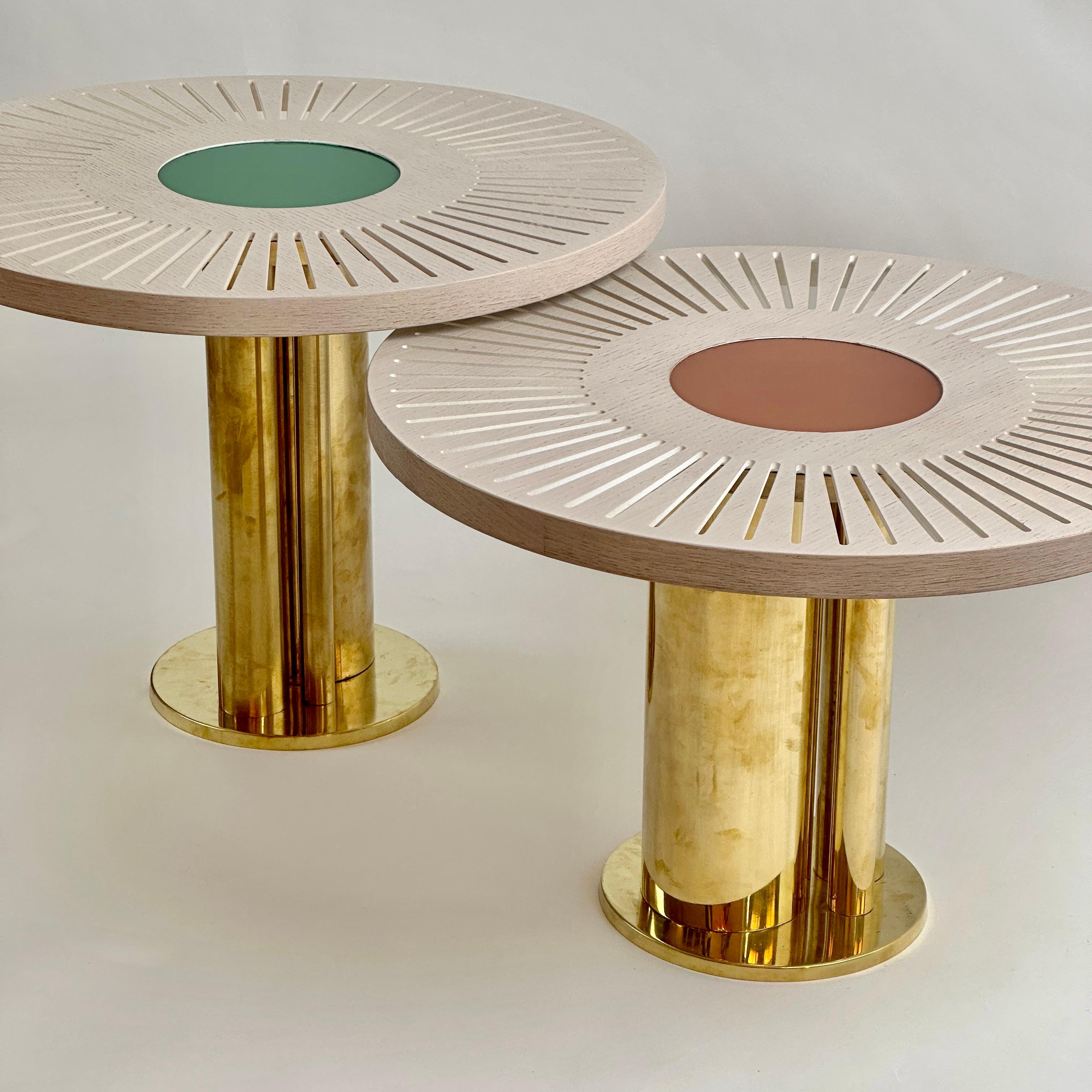 Pair of stunning round ash wood coffee tables with brick red and emerald green opaline glass centers. Brass basement with three brass cylinders each. The lower coffee table is 42 H cm.
Another pair of round side tables with powder pink & olive green