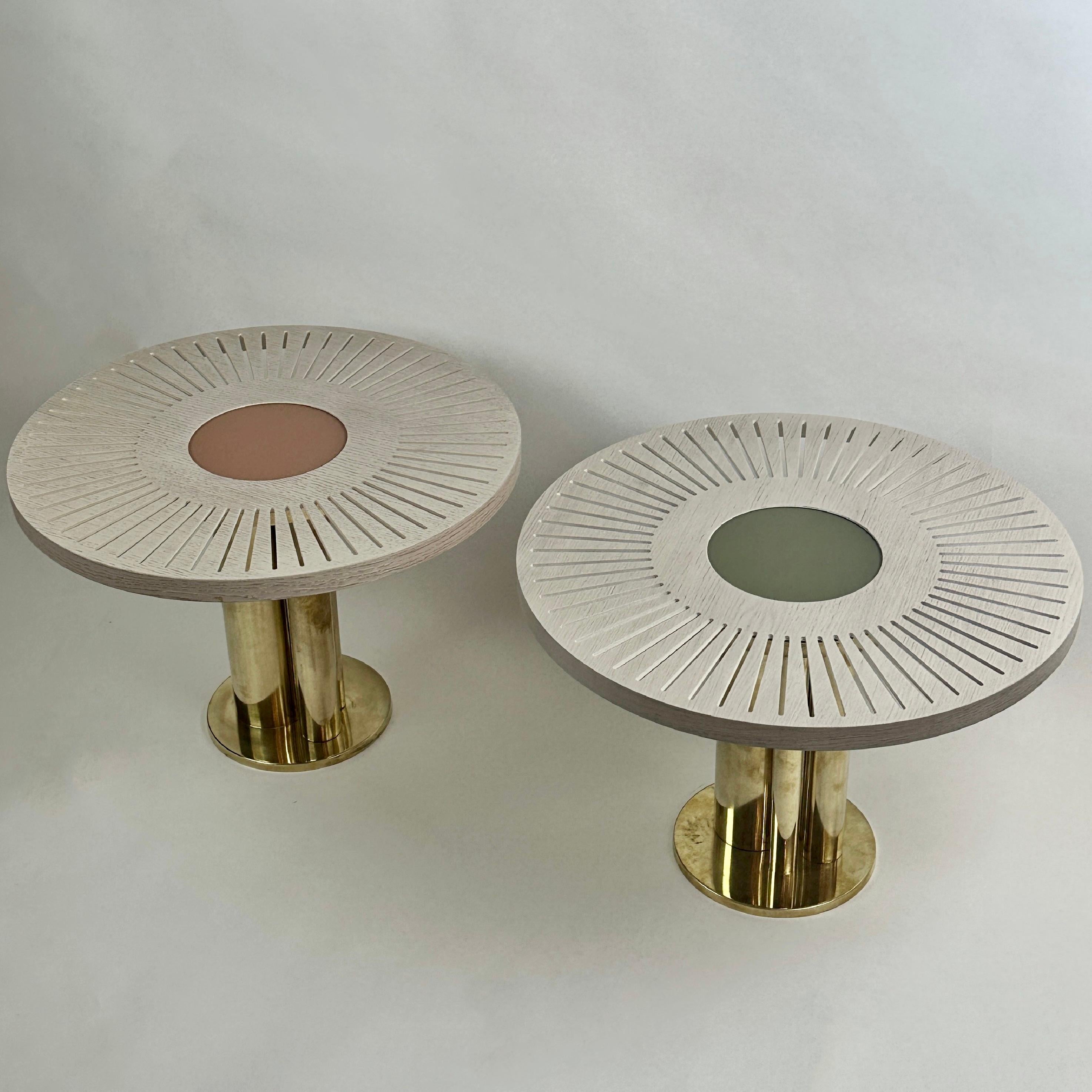 Pair of stunning round side tables with powder pink and olive green opaline glass centers. Brass basement with three brass cylinders each. 
Another pair of round coffee tables with brick red & emerald green opaline glass centers is available, in