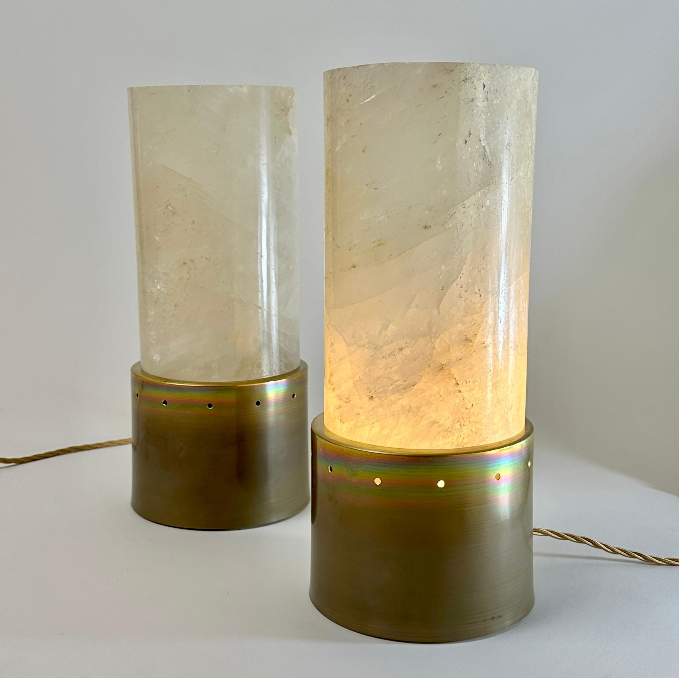 Stunning pair of extremely modern & collectible table lamps. The rock crystal cylinder is a solid block of 14 Diameter x 24 Height cm. placed on top of the round brass body.
One E27 Light Bulb each.
The Italian plugs have to be changed while the