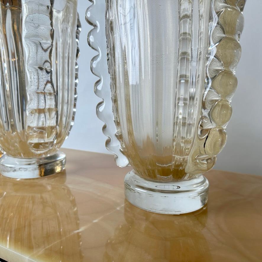 Late 20th century pair of classic transparent with gold glittering Murano art glass vases with lateral decorations by Costantini Murano (Hand signed on the bottom).