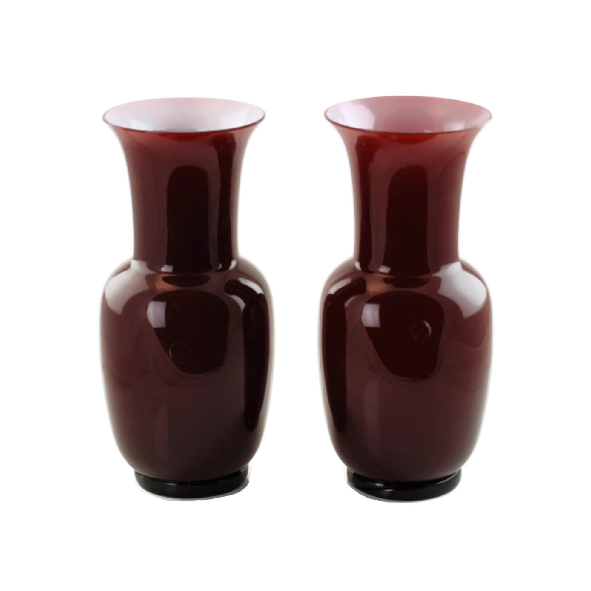 This elegant pair of late 20th century Venini opalino vases feature ruby red Oxblood glass with Lattimo 