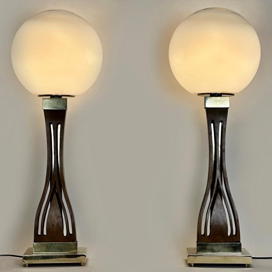 This pair of classic table lamps fit almost any kind of environment and they are perfect for any leaving room.
The mix of walnut, brass & faded blown Murano art glass give to these lamps a strong & stunning presence (only the top of boule is