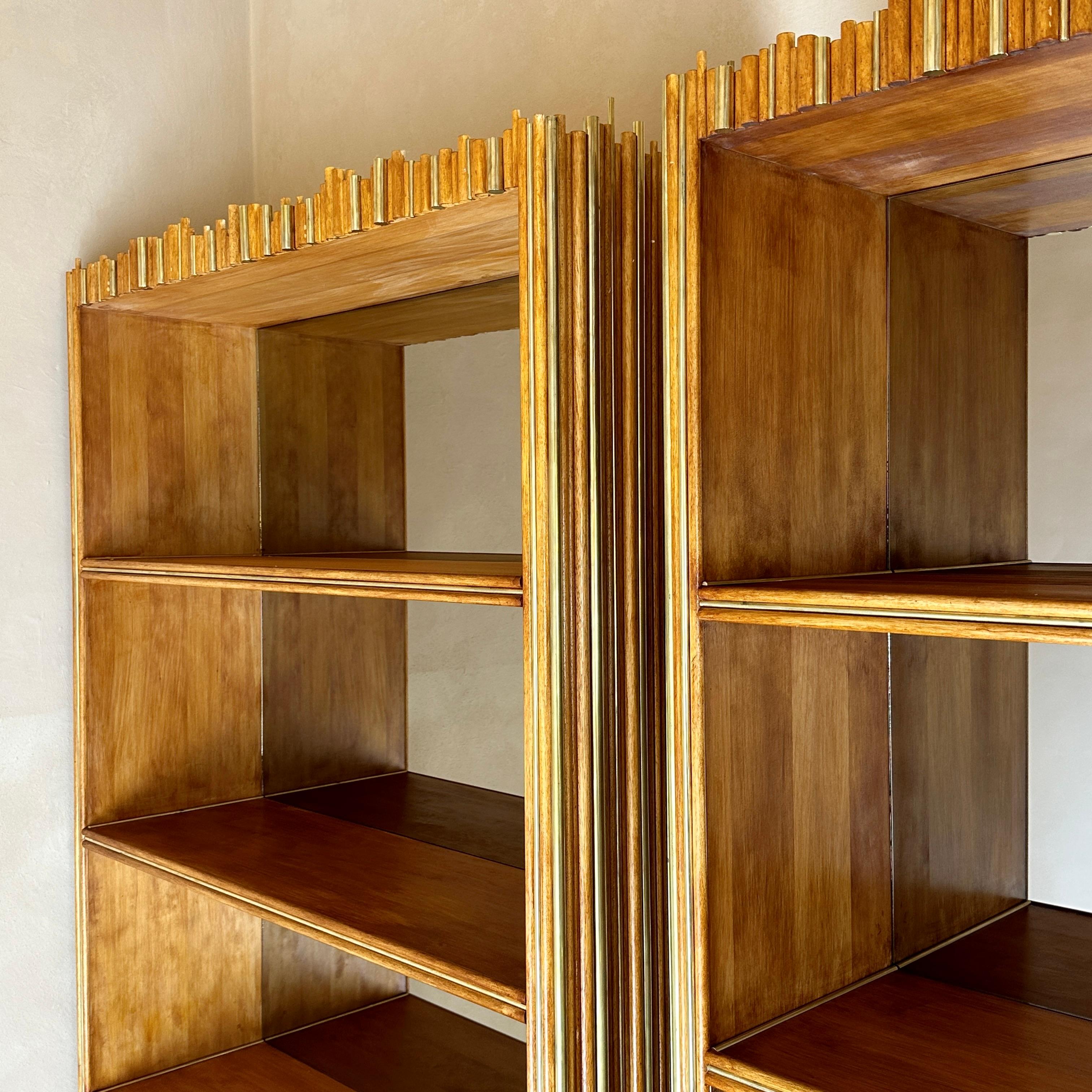 Stunning pair of Italian bookcases covered with walnut wood and brass sticks. Shelves are fixed and with bronzed mirrors in the back in order to help any collections of object come out live and bright.