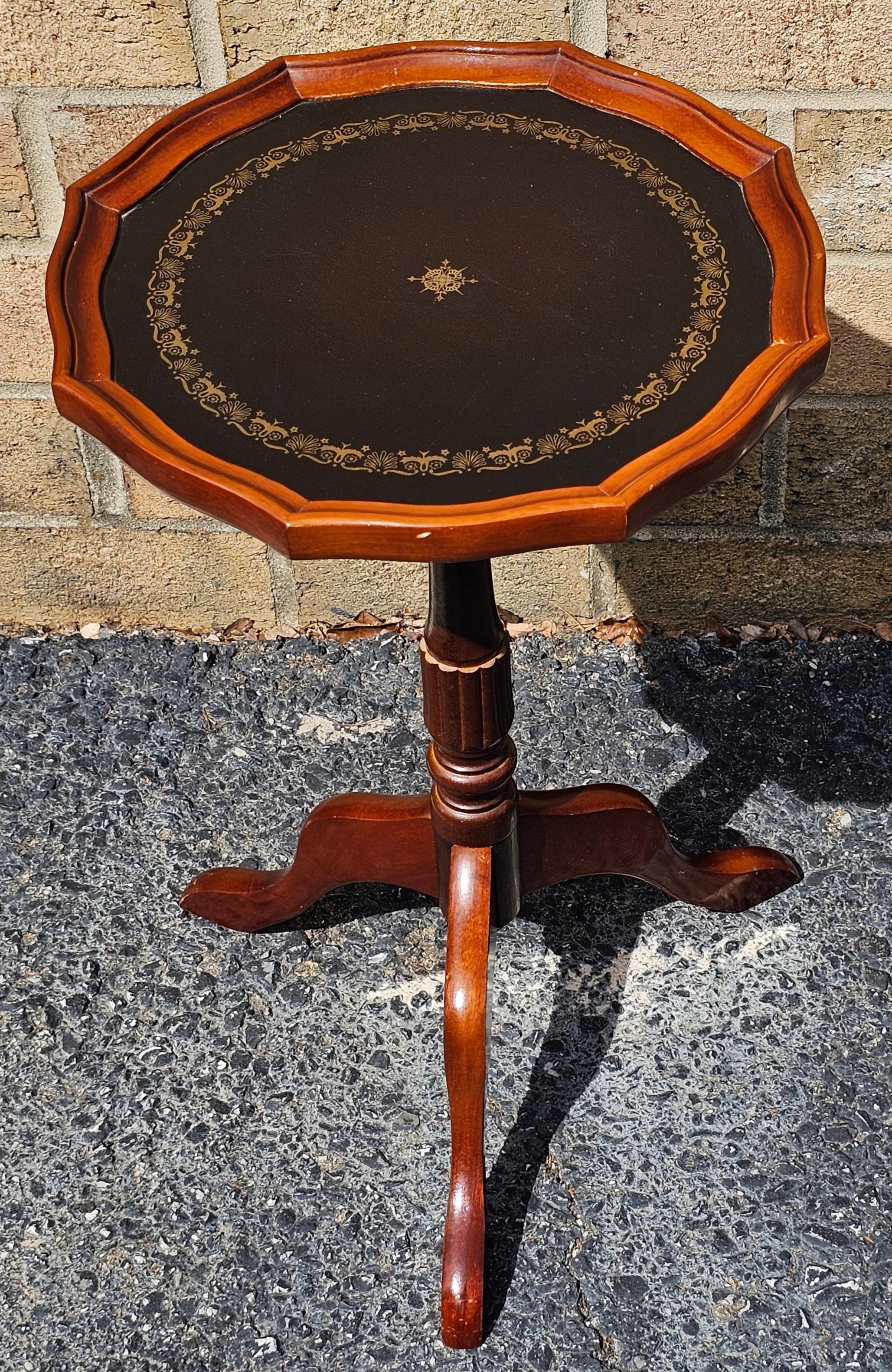 Porte-bougies en acajou de la fin du 20e siècle, à piédestal et à trépied, avec dessus en cuir tolélé au pochoir. 
Mesure 13