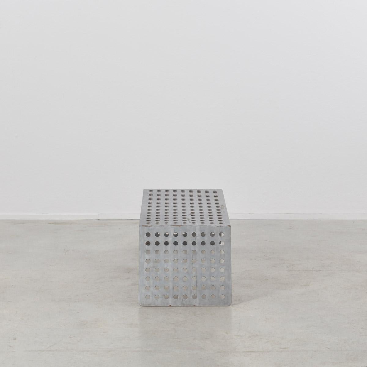 This minimal vintage table made from bent perforated raw aluminum sheet could be used as a coffee table or side table, or even for books or dressing at the end of a bed.

The underside is supported with two rods of metal allowing it to take some